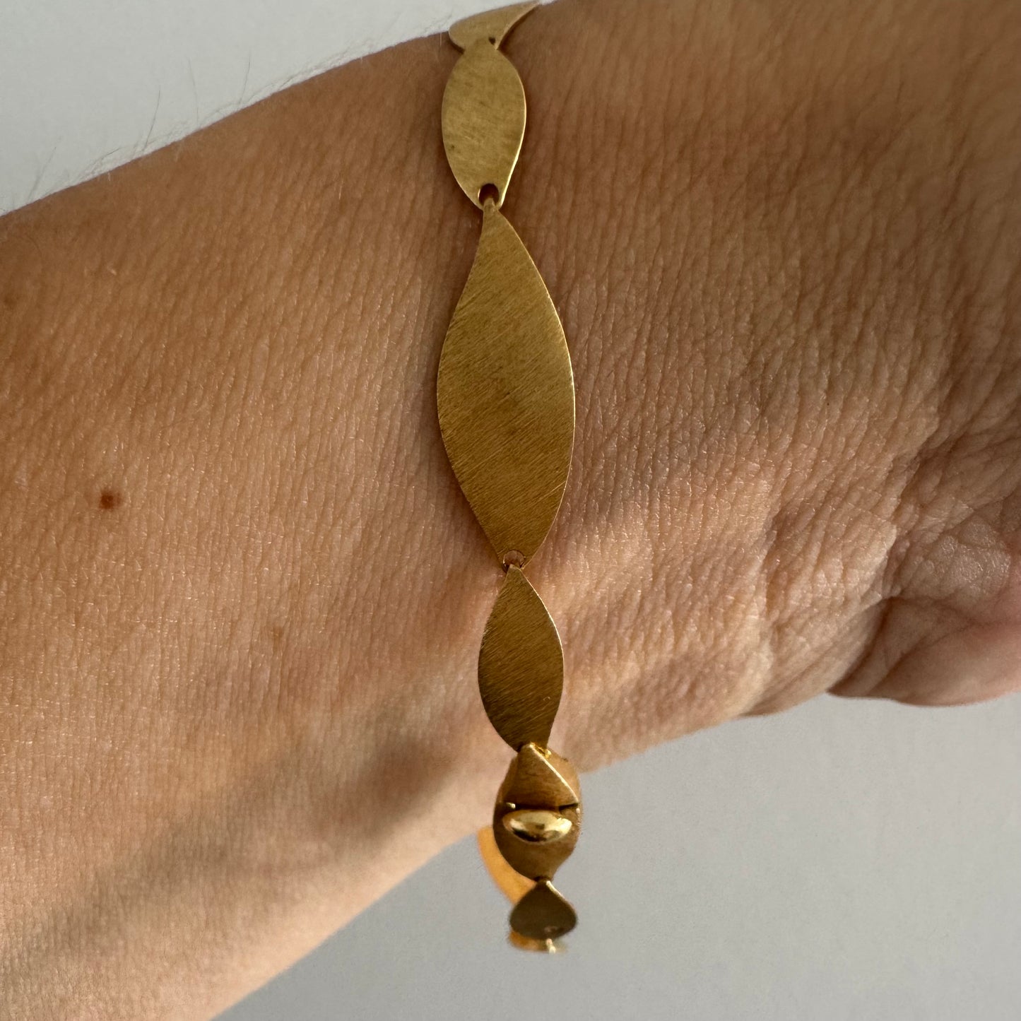 צמיד יוקרתי של המותג H.Stern, עשוי זהב 18 קראט, בעיצוב עלים מחוספסים במראה משי מט. 