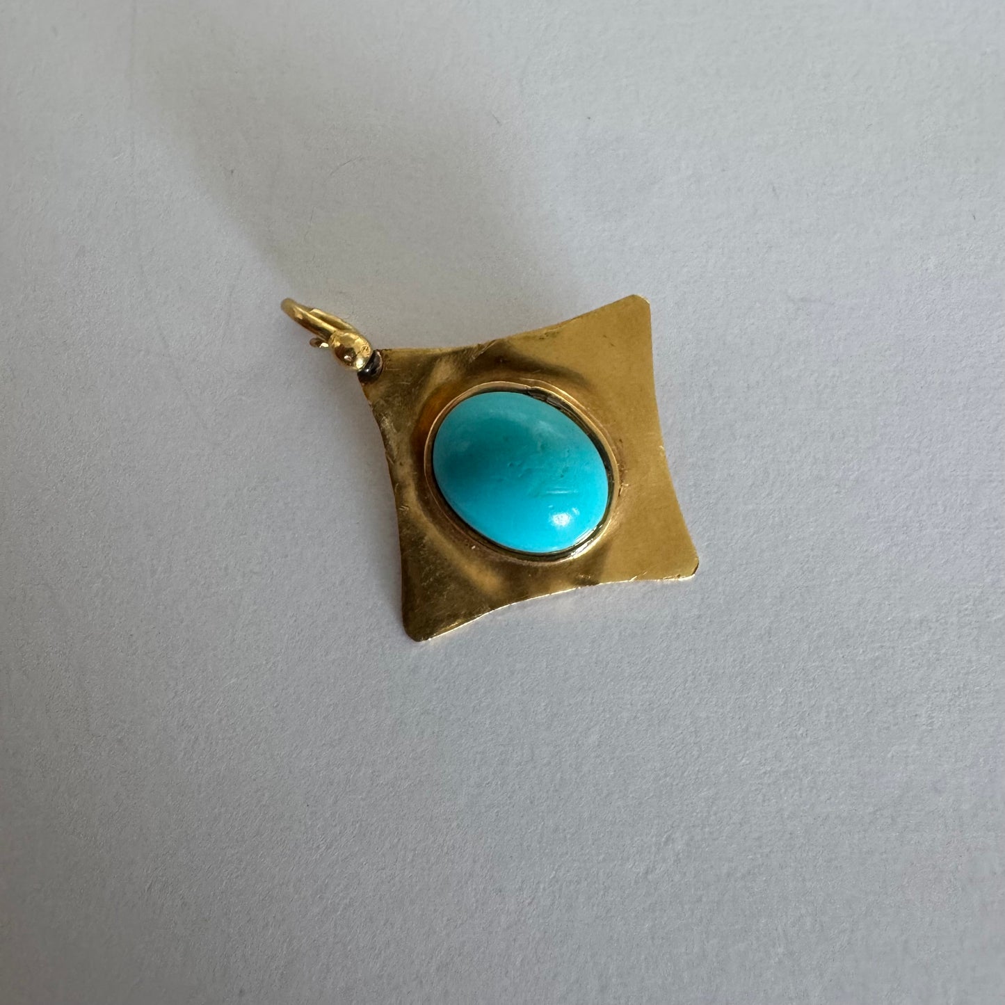 18K gold pendant set with a vibrant Turquoise stone in a bold, geometric design.