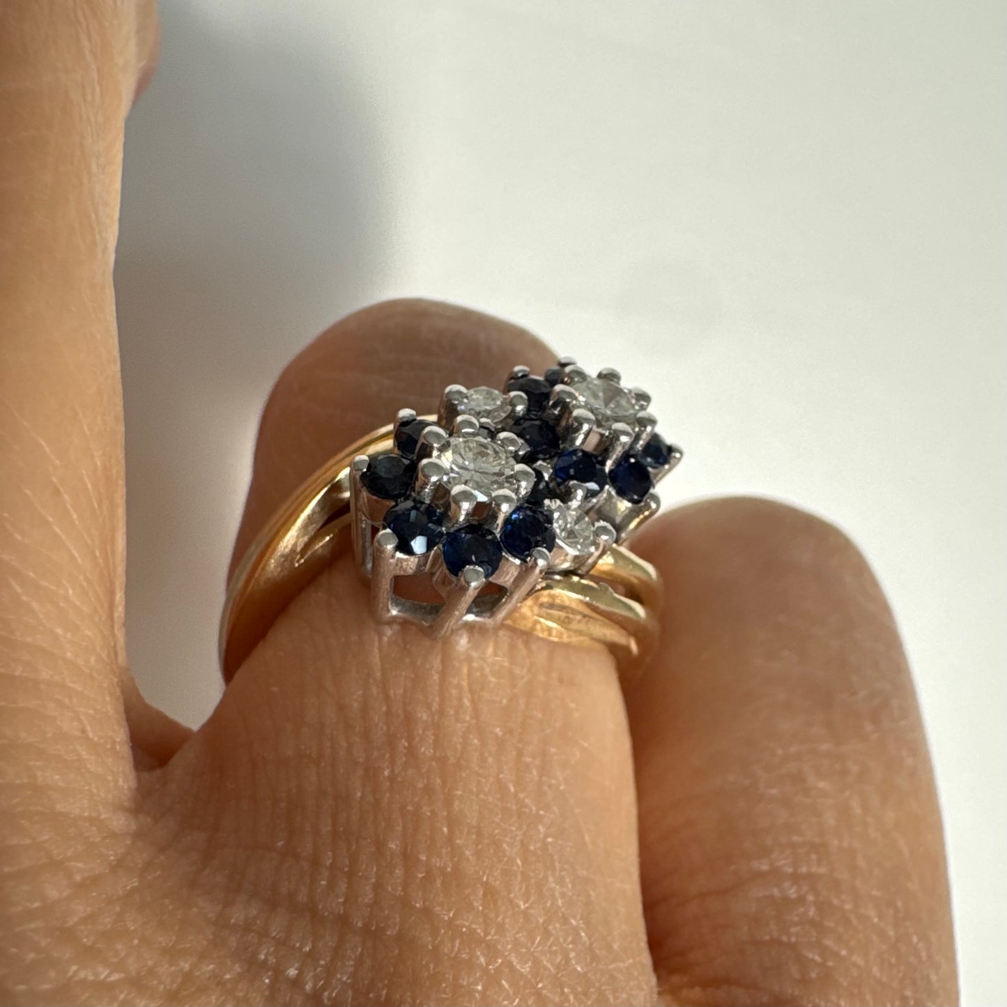 טבעת זהב צהוב 14 קראט משובצת אבני ספיר ויהלומים בעיצוב פרחים כפול.