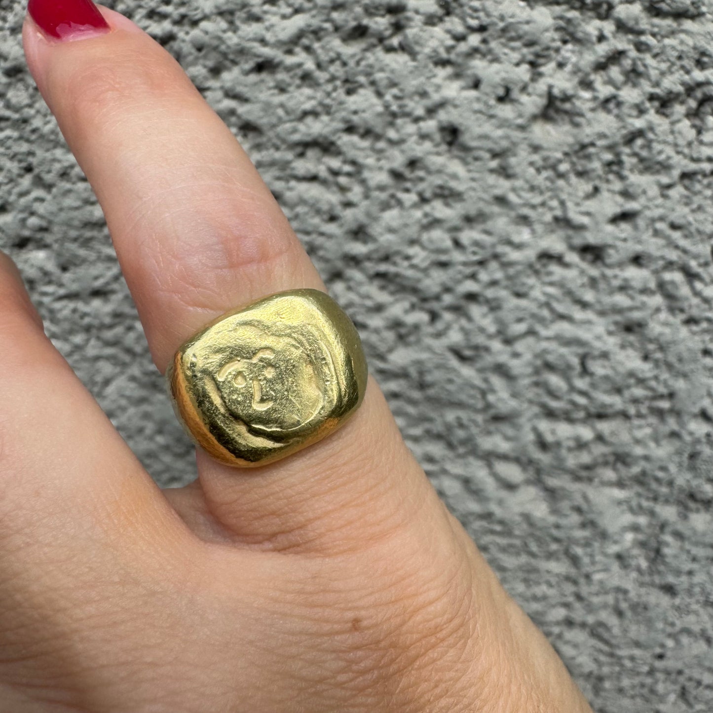 18K gold chunky gold ring with a rustic, organic finish, featuring an engraved abstract face motif at its center.