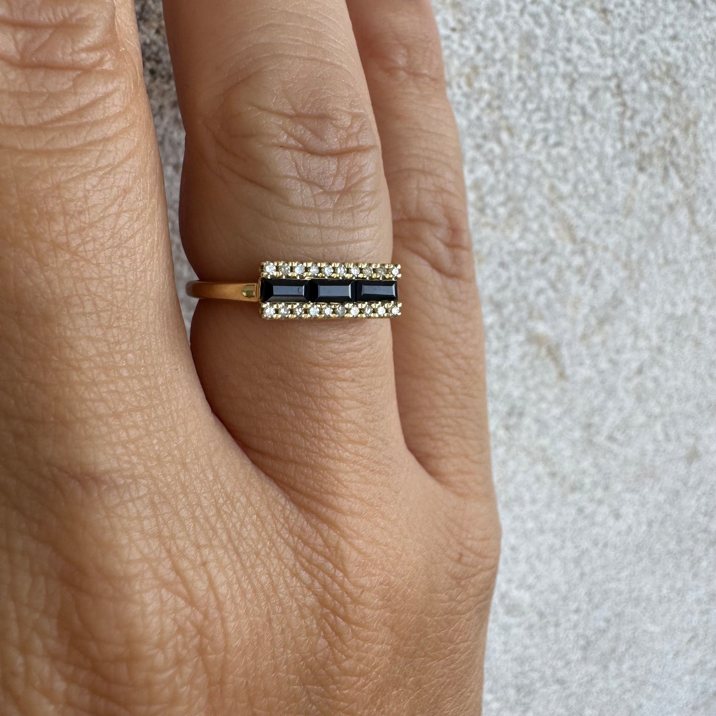 14K gold ring set with baguette-cut Sapphire framed by sparkling Diamonds