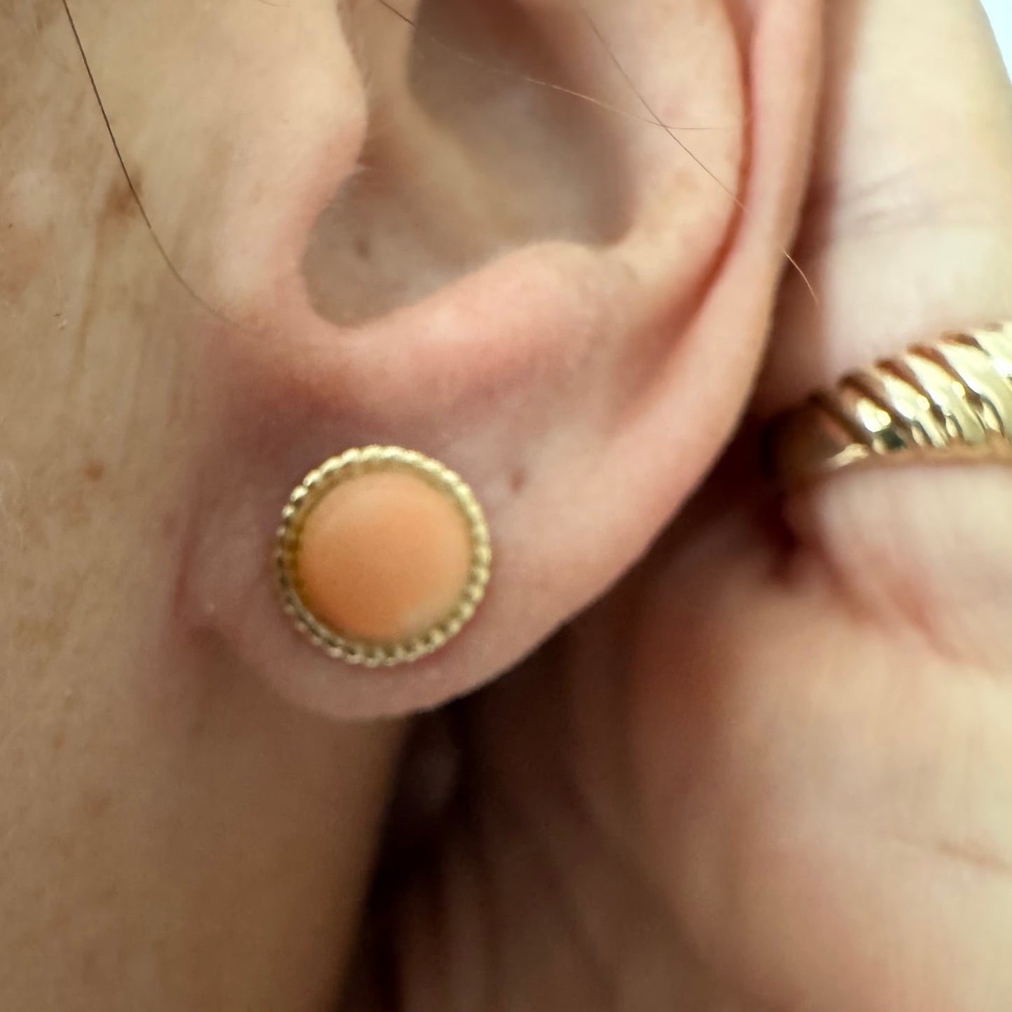 14K gold stud earrings set with natural Coral stones in a soft peach-pink tone.