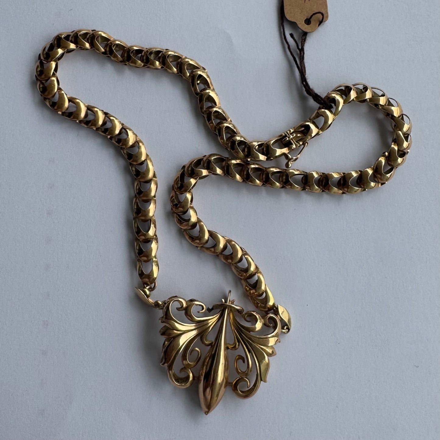 שרשרת זהב 14 קראט בעלת עיטור פלר דה ליס (Fleur-de-lis) אמנותי, המעוצב בקווים מעוגלים של עלי שושן בסגנון אר נובו.