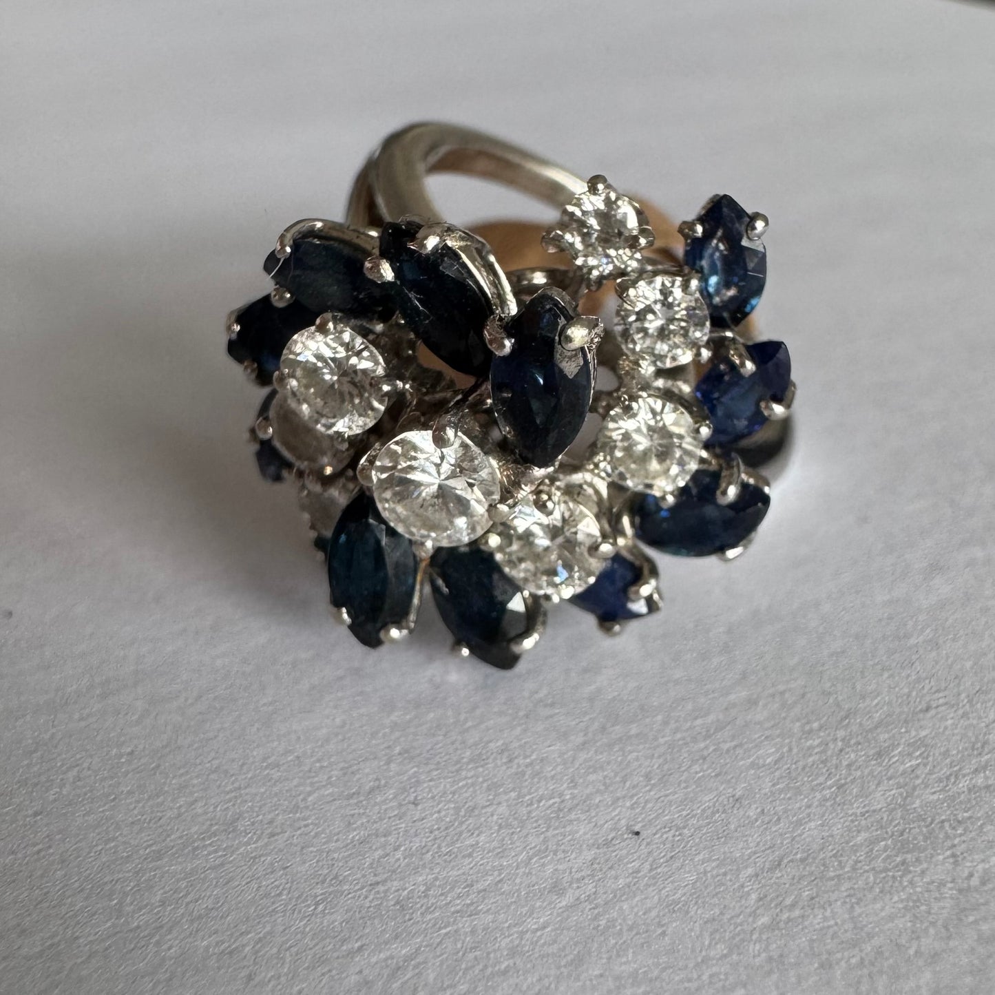 18K white gold ring, set with marquise-cut blue Sapphires and round Diamonds, in a classic cluster design.