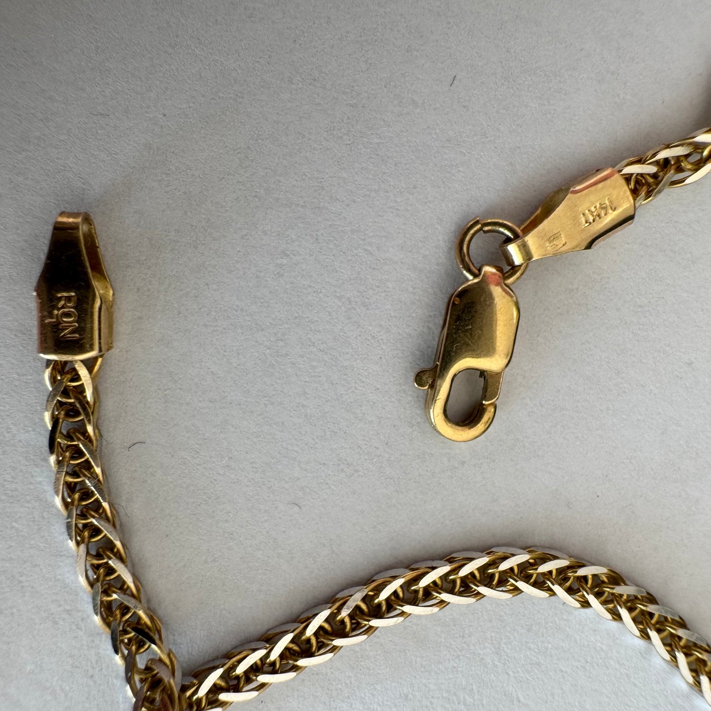 שרשרת זהב צהוב 14 קראט בעיצוב חוליות קלועות היוצרות מראה עשיר ומלא ברק.