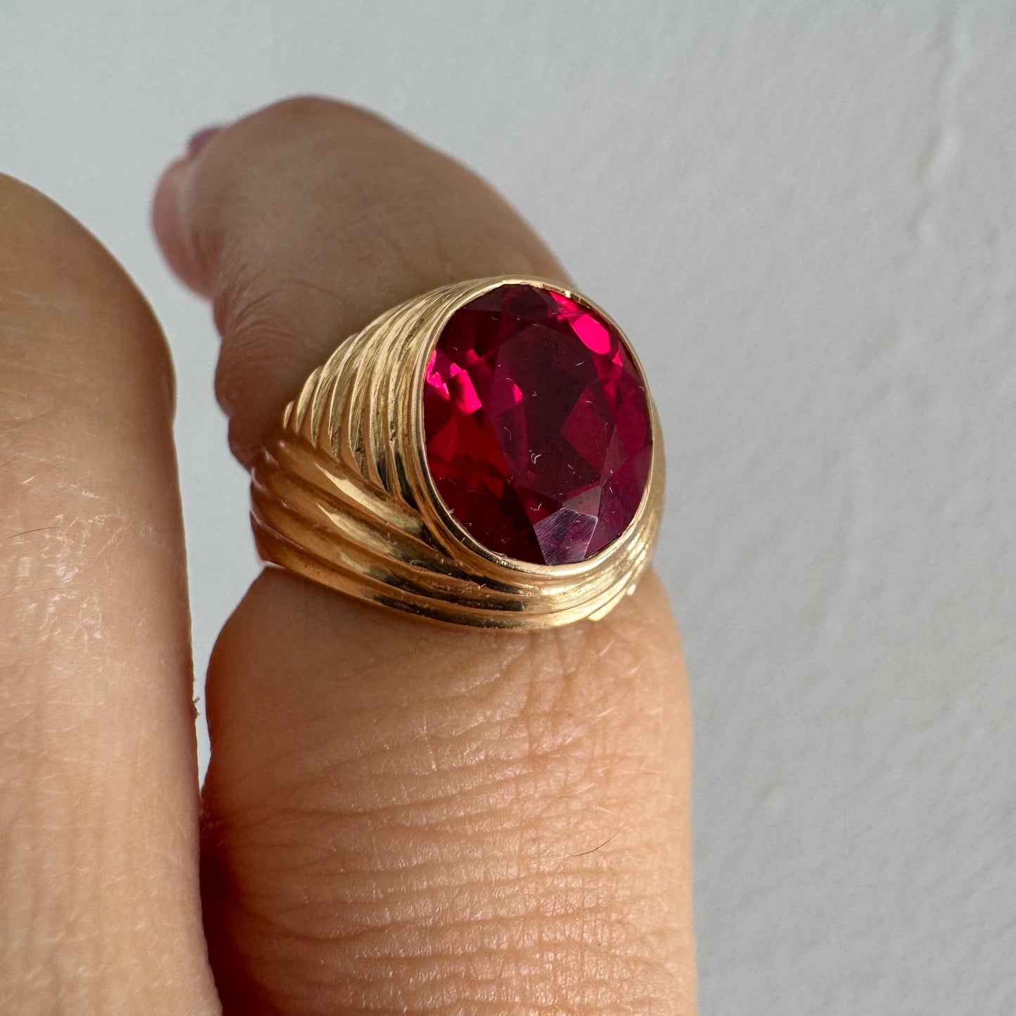 18K gold ring set with a striking oval-cut Ruby gemstone.
