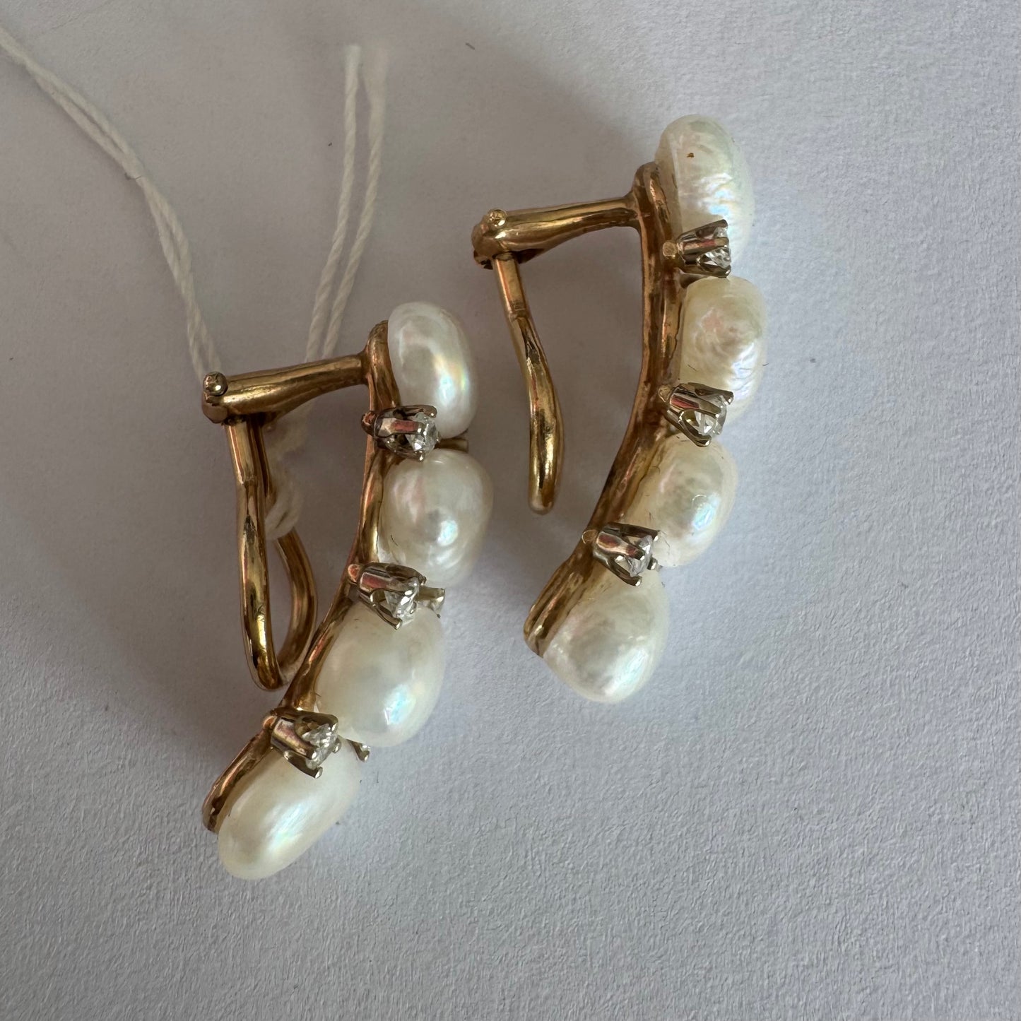14K gold clip-on earrings set with Pearls accented by sparkling Diamonds between each pearl