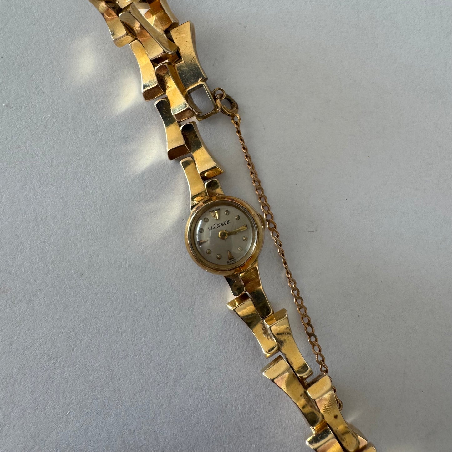 שעון נשים של Jaeger-LeCoultre מזהב 18 קראט, בעל צמיד אינטגרלי בעיצוב פיסולי ולוח מחוגים מינימליסטי ואלגנטי.