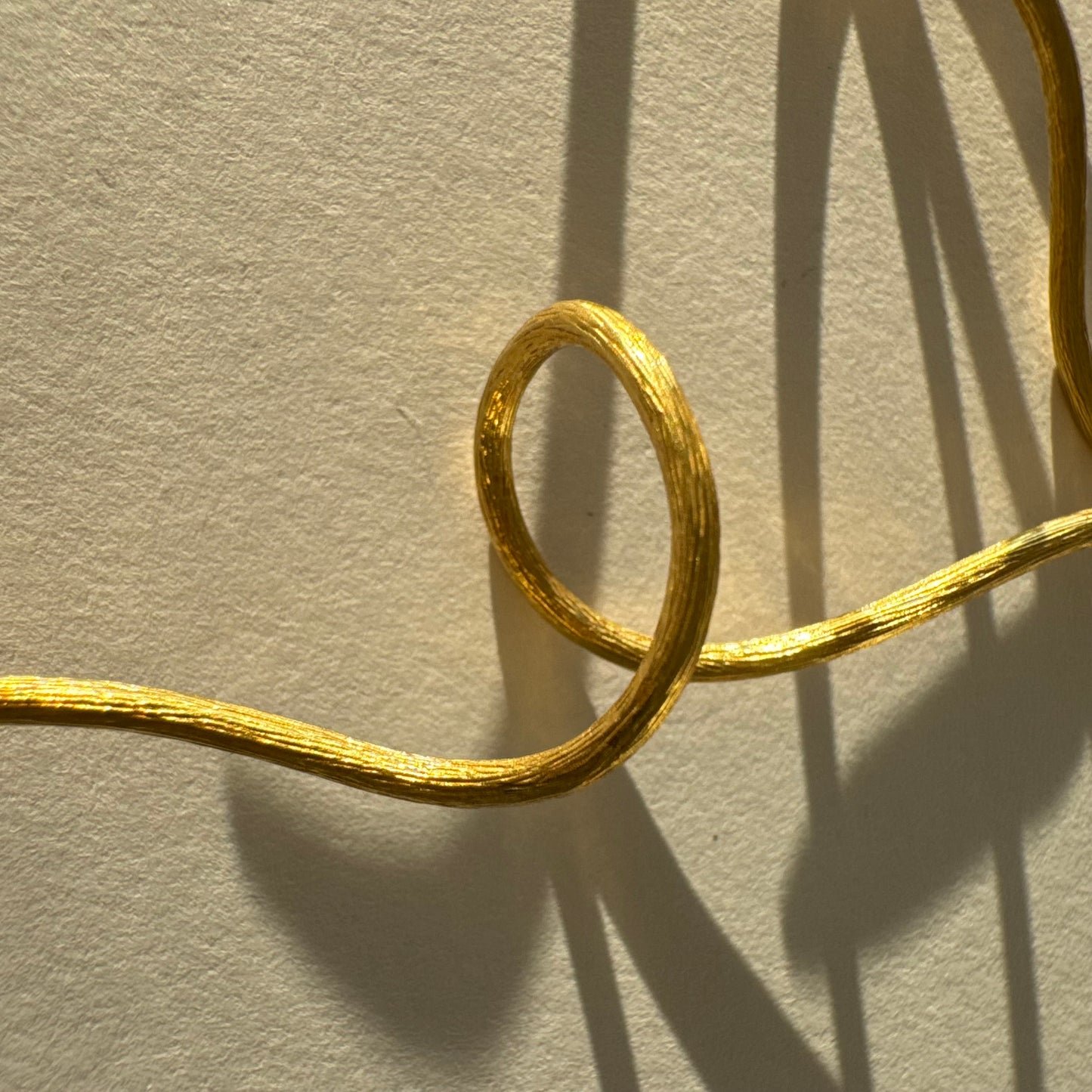 עגילי זהב צהוב 18 קראט מבית ה.שטרן, בעיצוב פיסולי וייחודי עם קווים זורמים ודינמיים.