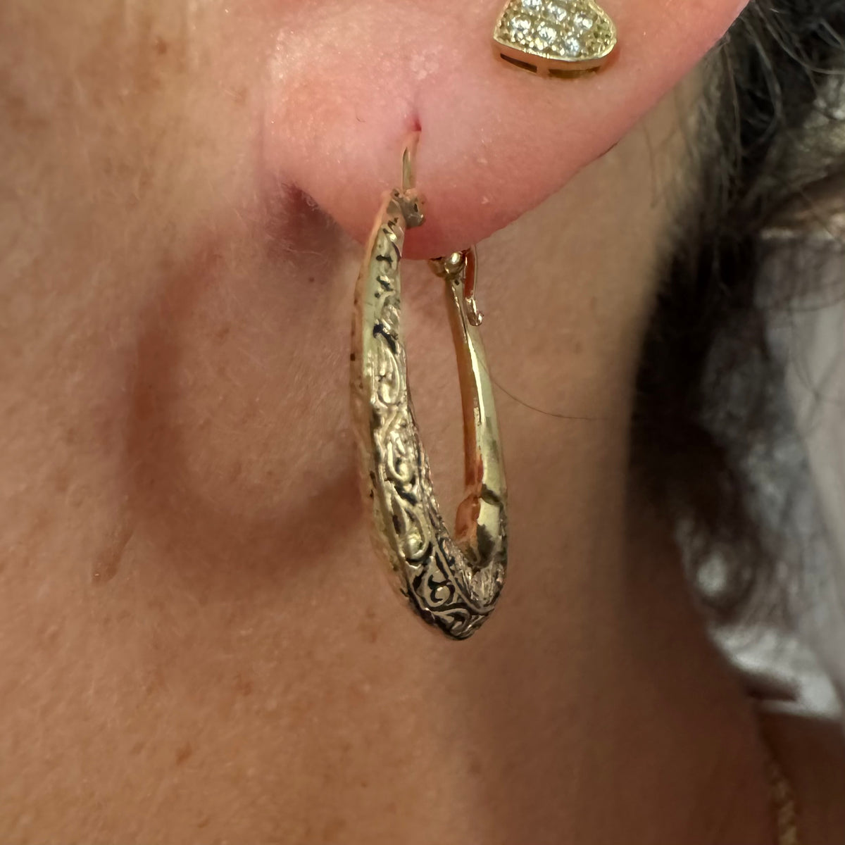 14K gold hoop earrings featuring an intricate openwork design and beautifully detailed engraving