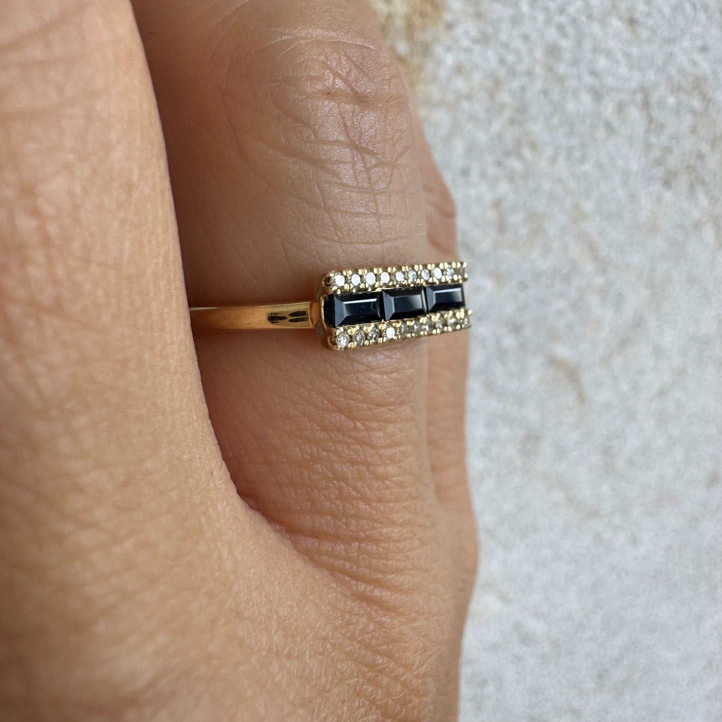 14K gold ring set with baguette-cut Sapphire framed by sparkling Diamonds