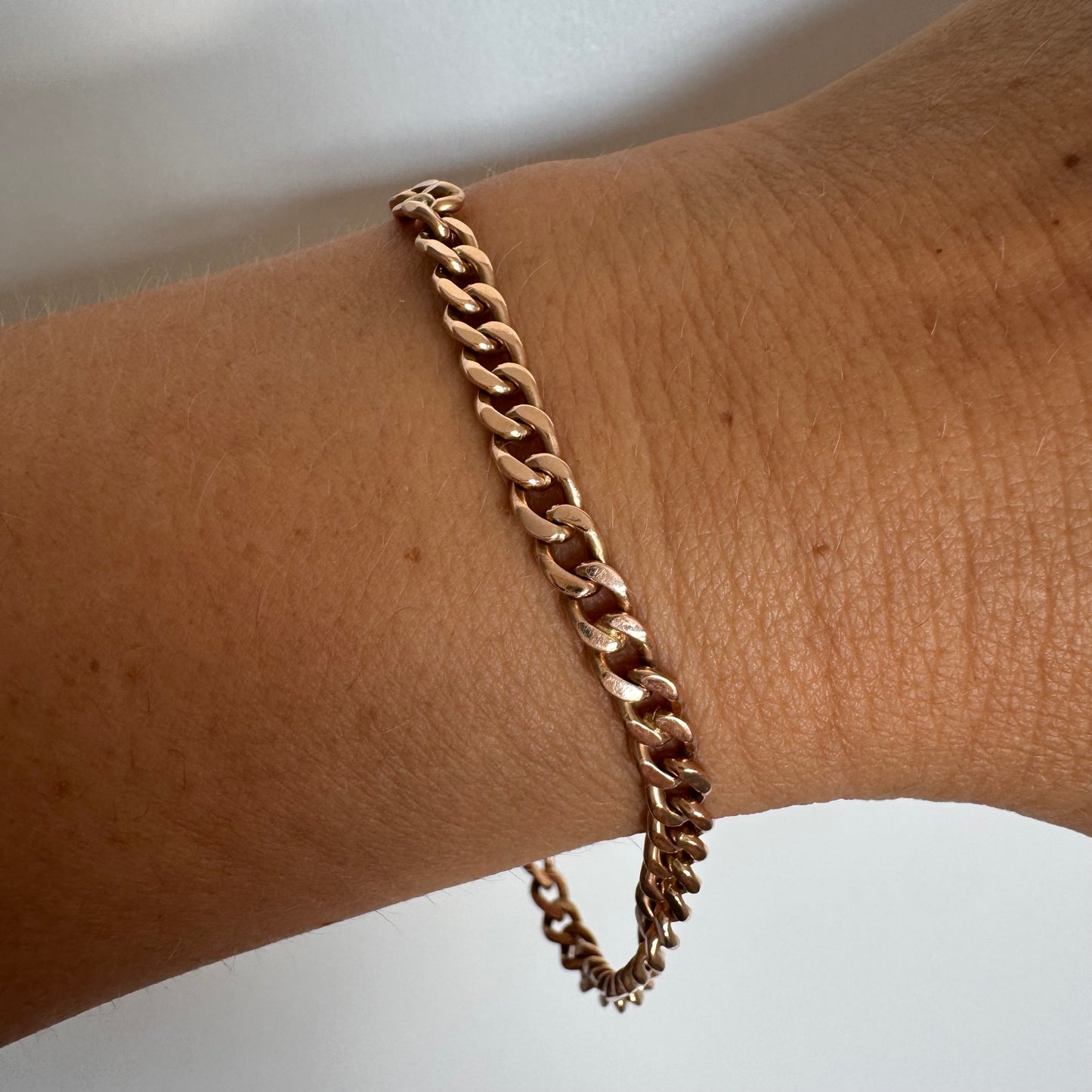 14K gold bracelet featuring a classic chain-link design with a sleek, elegant presence on the wrist.