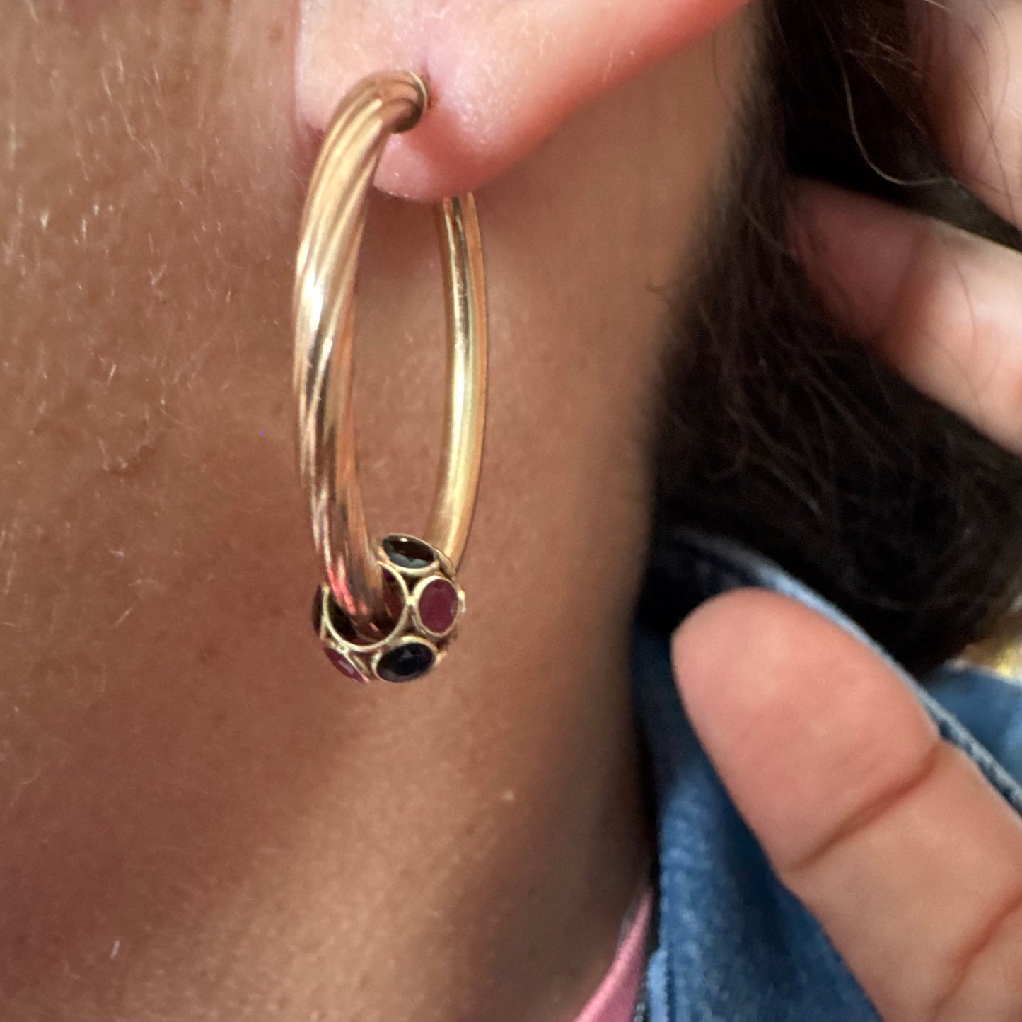10K gold hoop earrings with a twisted design, set with pink and green Tourmaline.