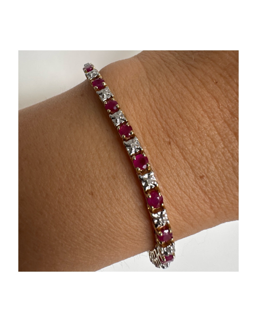 צמיד זהב צהוב 10 קראט משובץ אבני רובי בגוון אדום עמוק וביניהן יהלומים לבנים מנצנצים.