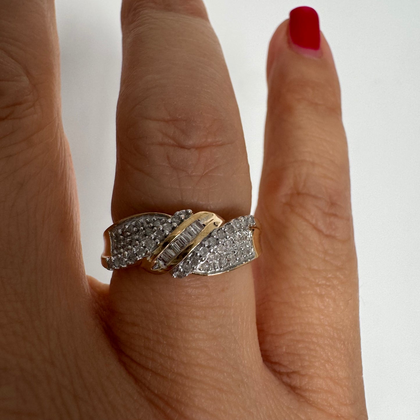 טבעת זהב 10 קראט משובצת יהלומים בחיתוך עגול לצד שורת יהלומי בגט במרכז.