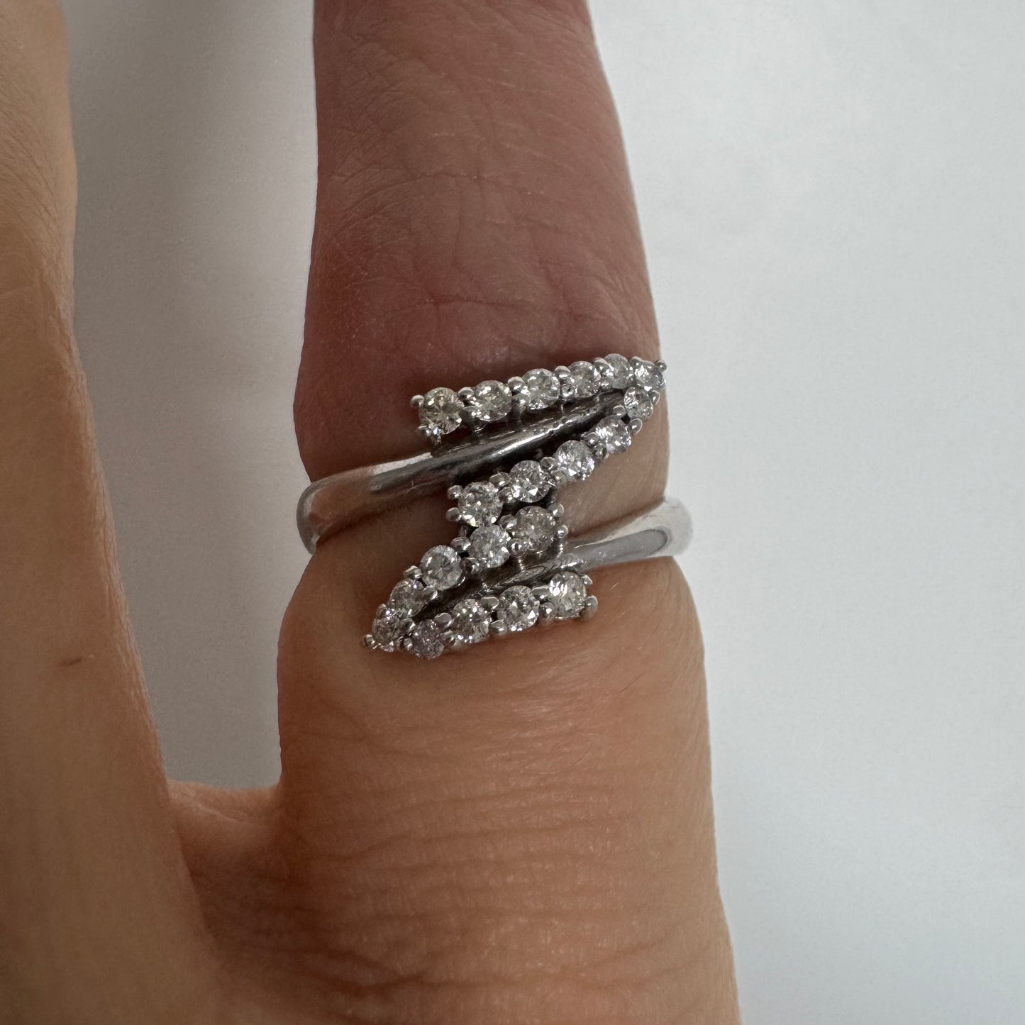 14K gold ring with an open design, featuring two curved rows of sparkling Diamonds that cross over each other elegantly.