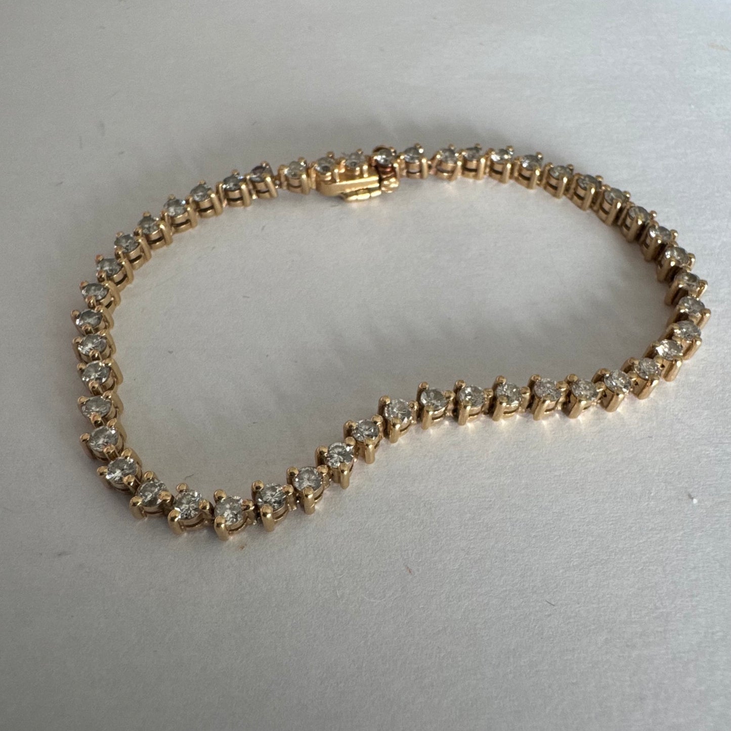 14K gold tennis bracelet set with a continuous line of round Diamonds, creating a delicate and elegant sparkle.