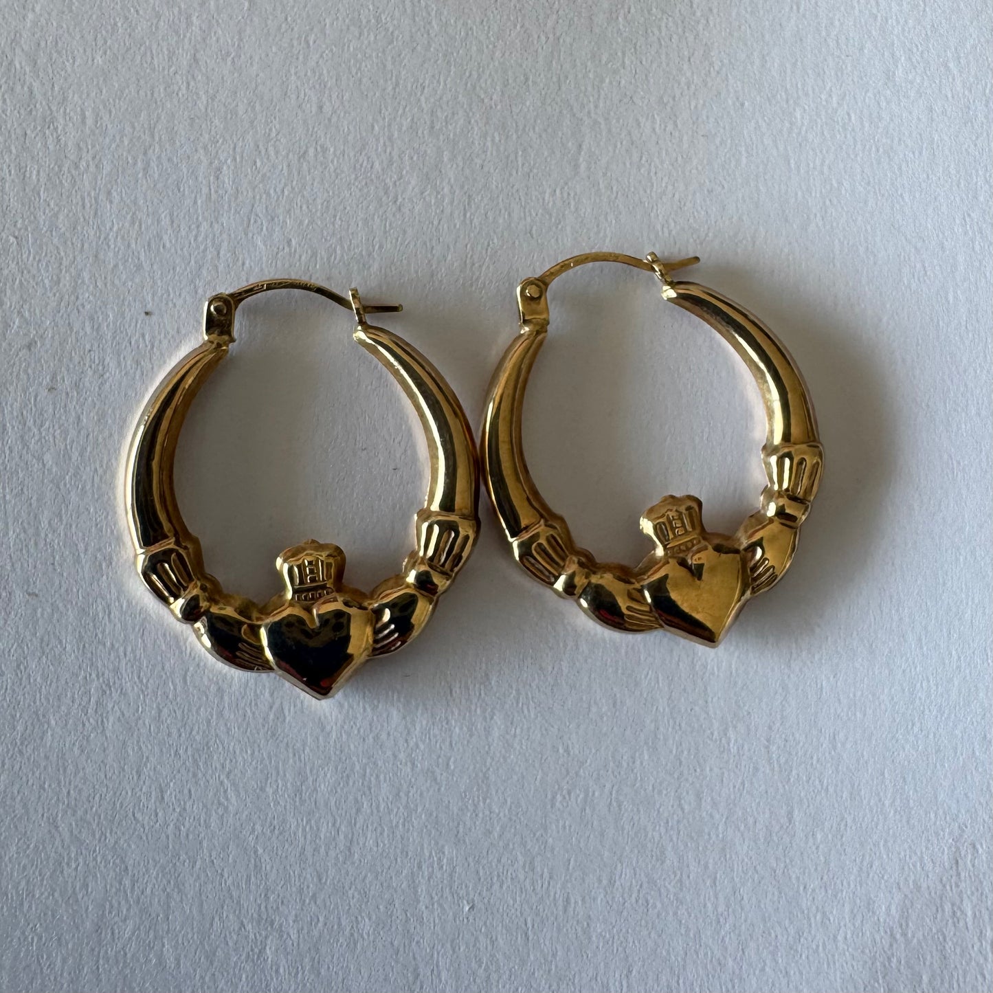 9K gold Claddagh earrings, featuring the iconic Irish motif of a heart held by two hands and topped with a crown, traditionally symbolizing love, friendship and loyalty.