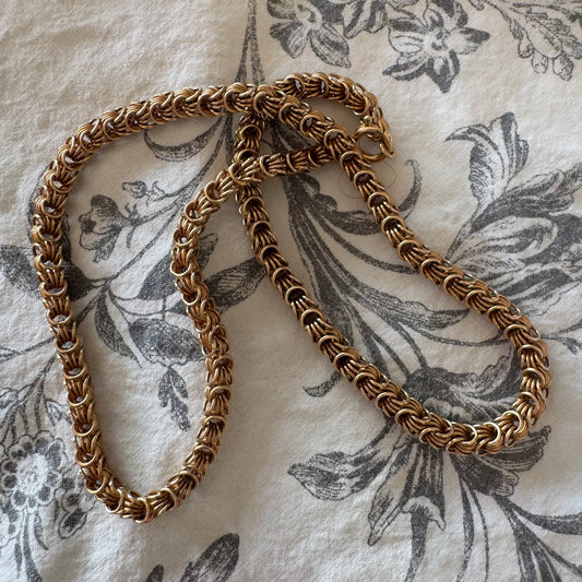 14K gold necklace featuring intricate, interwoven links that create a rich and textured look.