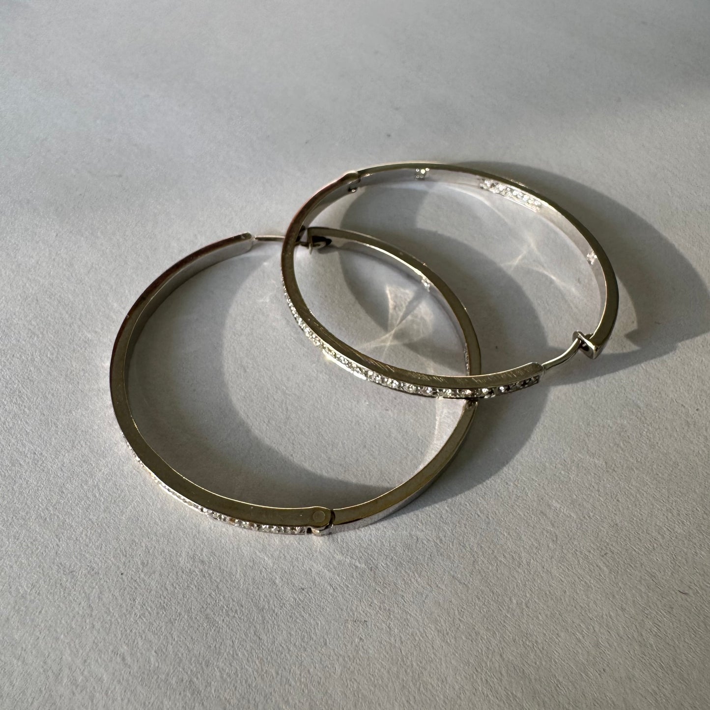 עגילי חישוק זהב 18 קראט, משובצים יהלומים לכל אורכם בחזית ובחלק הפנימי.