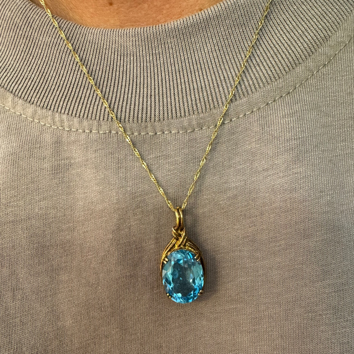 9K gold Pendant set with a striking oval-cut Blue Topaz