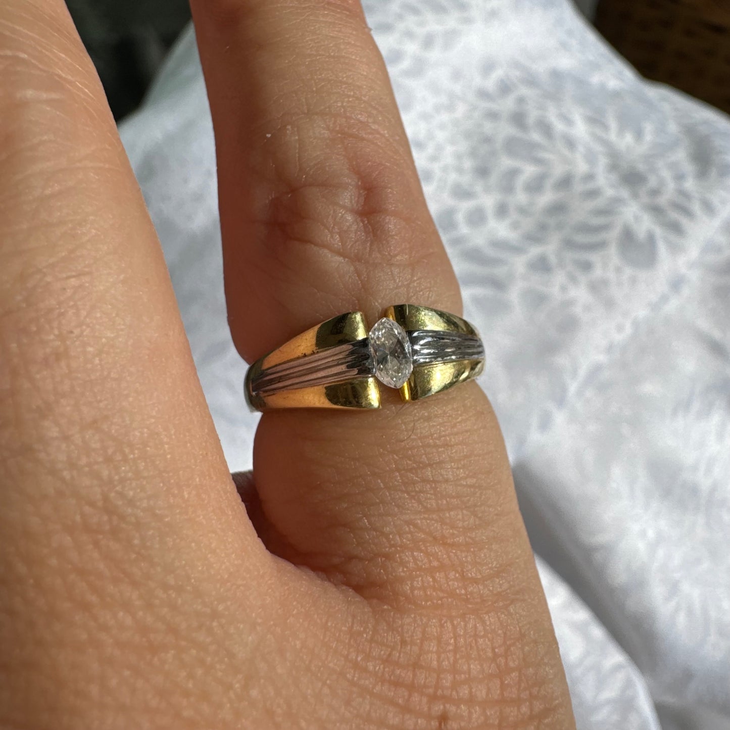 טבעת זהב 18 קראט בעיצוב דו-גוני של זהב צהוב ולבן, משובצת יהלום בחיתוך מרקיזה. 
