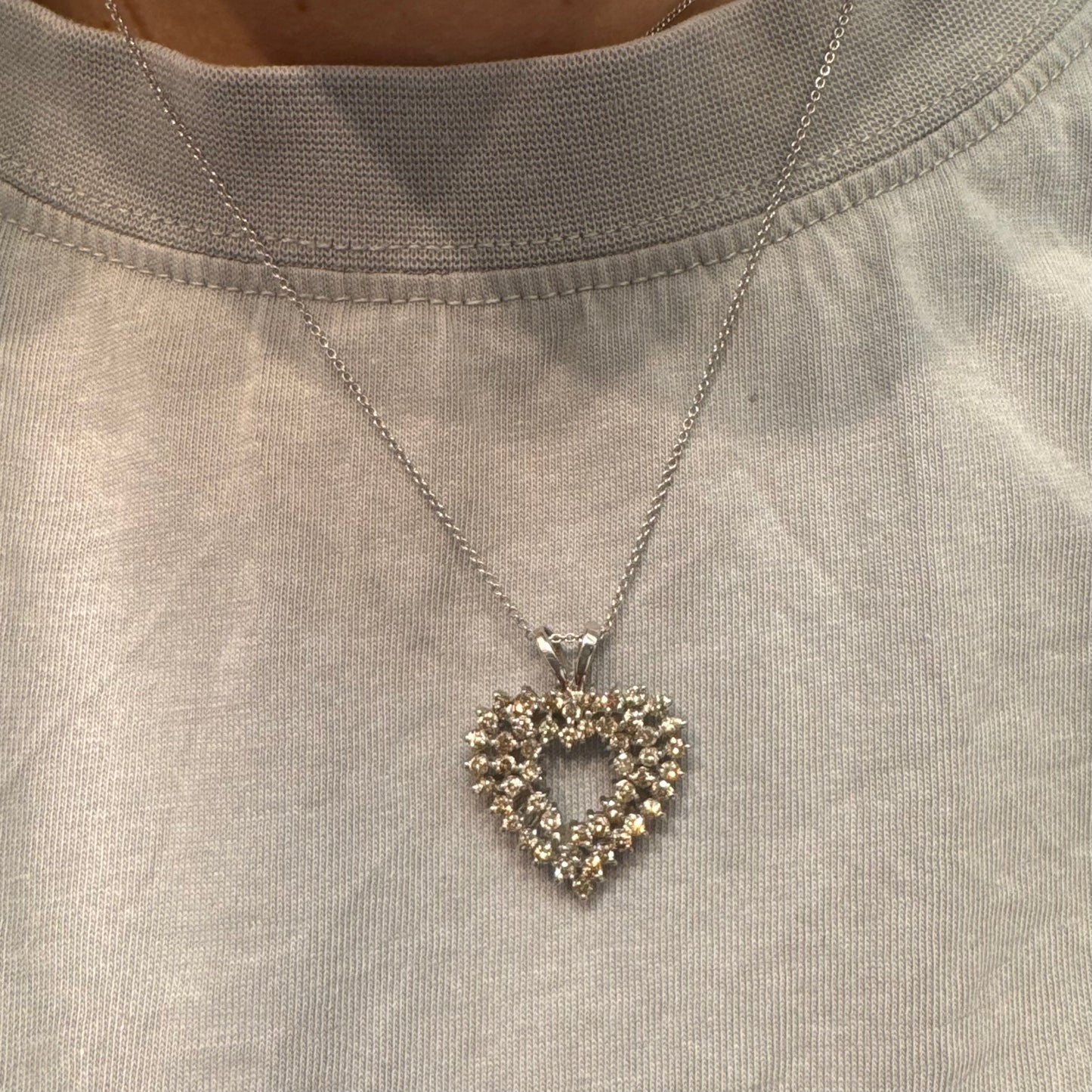 תליון לב זהב לבן 14 קראט, משובץ יהלומים בשיבוץ שיניים עדין היוצר מראה עשיר ומלא ברק.