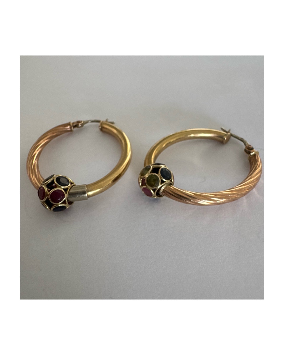 10K gold hoop earrings with a twisted design, set with pink and green Tourmaline.