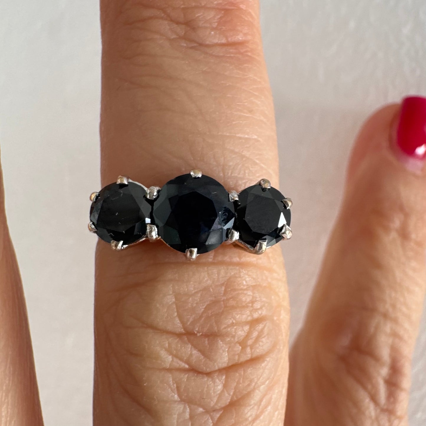 טבעת זהב 10 קראט משובצת שלוש אבני ספיר בצבע כחול כהה בחיתוך עגול, בעיצוב קלאסי עם נוכחות עמוקה ואלגנטית.