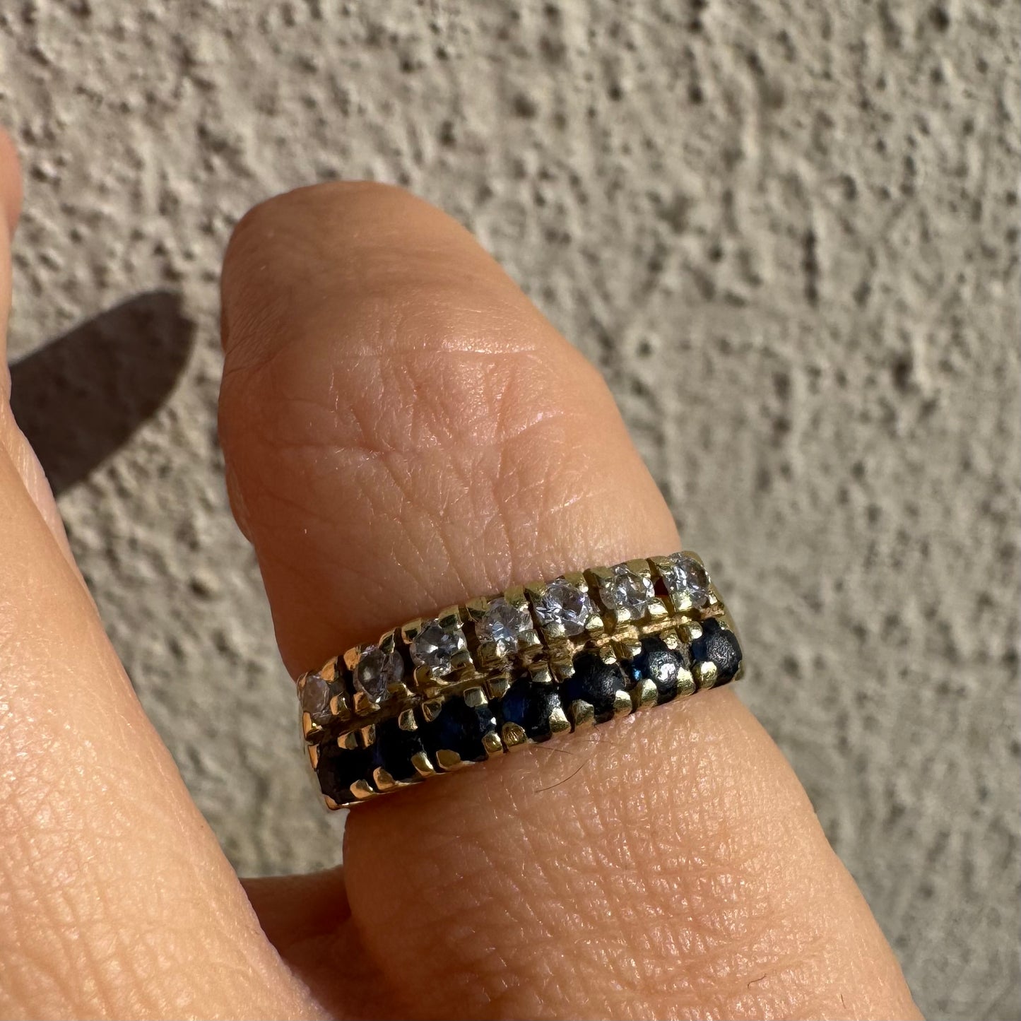 טבעת זהב צהוב 14 קראט, עם שורה של יהלומים נוצצים ושורה נוספת של ספירים כחולים.