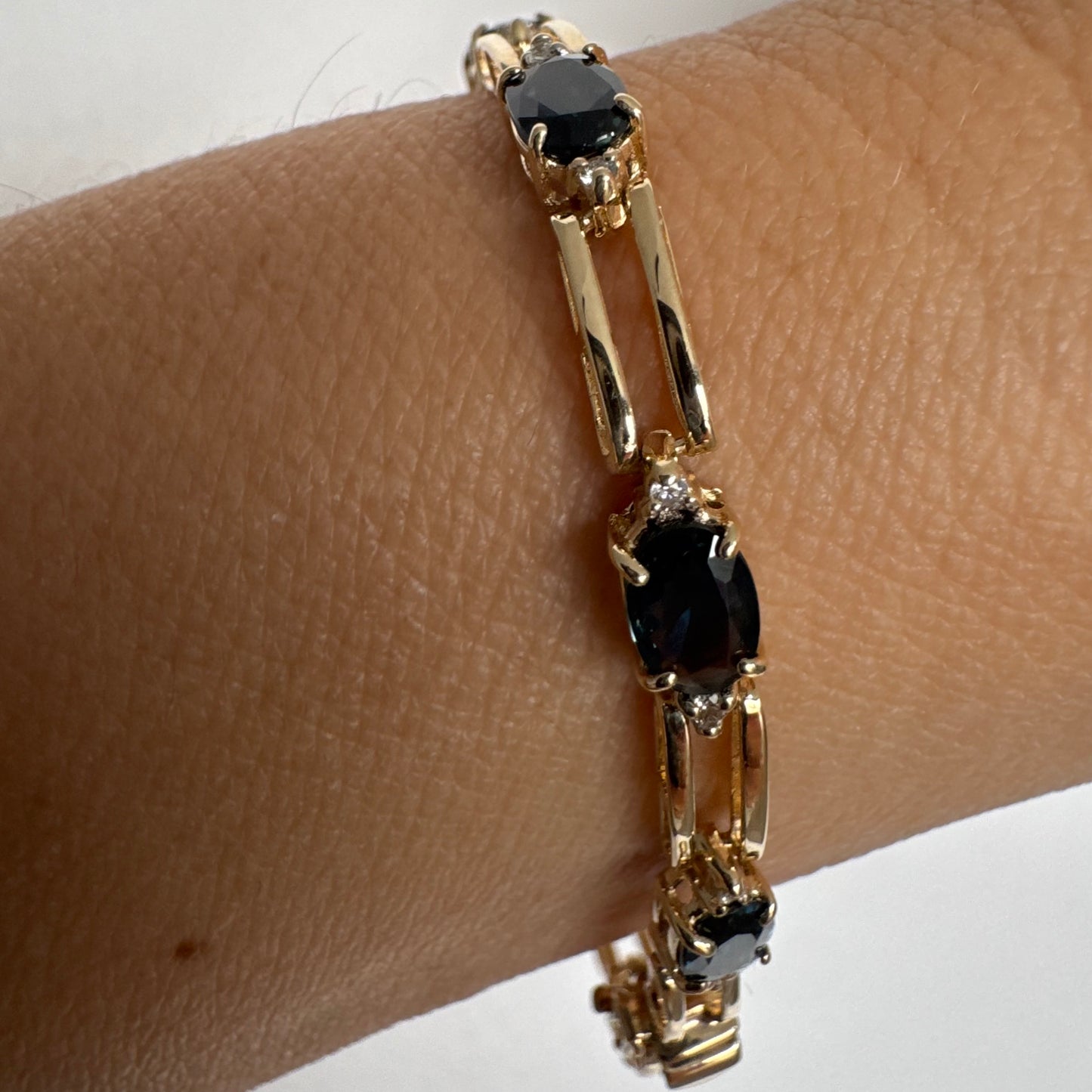 צמיד זהב צהוב 14 קראט משובץ אבני טופז כחולות בחיתוך אובלי, עם יהלומים המשובצים ביניהן להוספת ברק עדין.