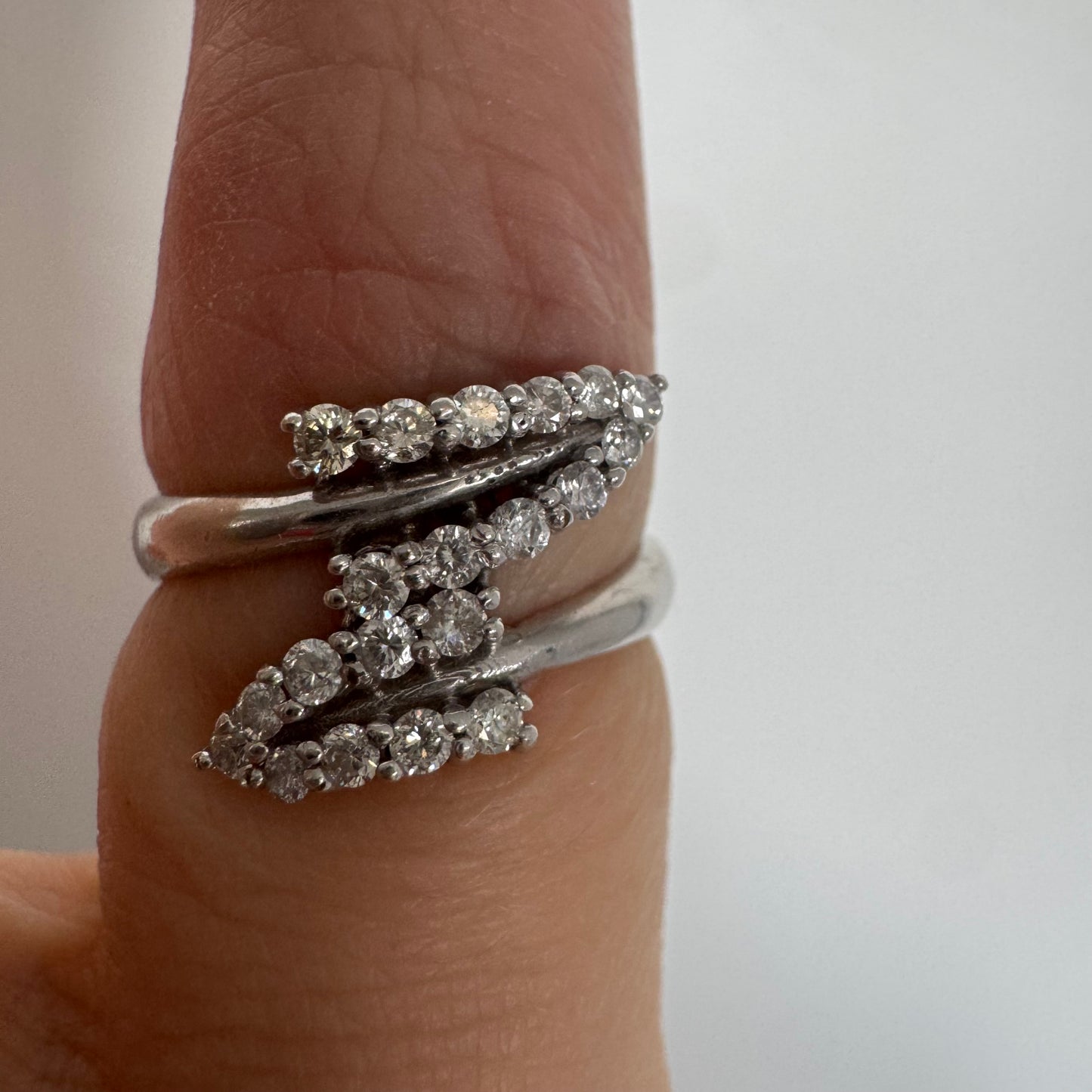 14K gold ring with an open design, featuring two curved rows of sparkling Diamonds that cross over each other elegantly.