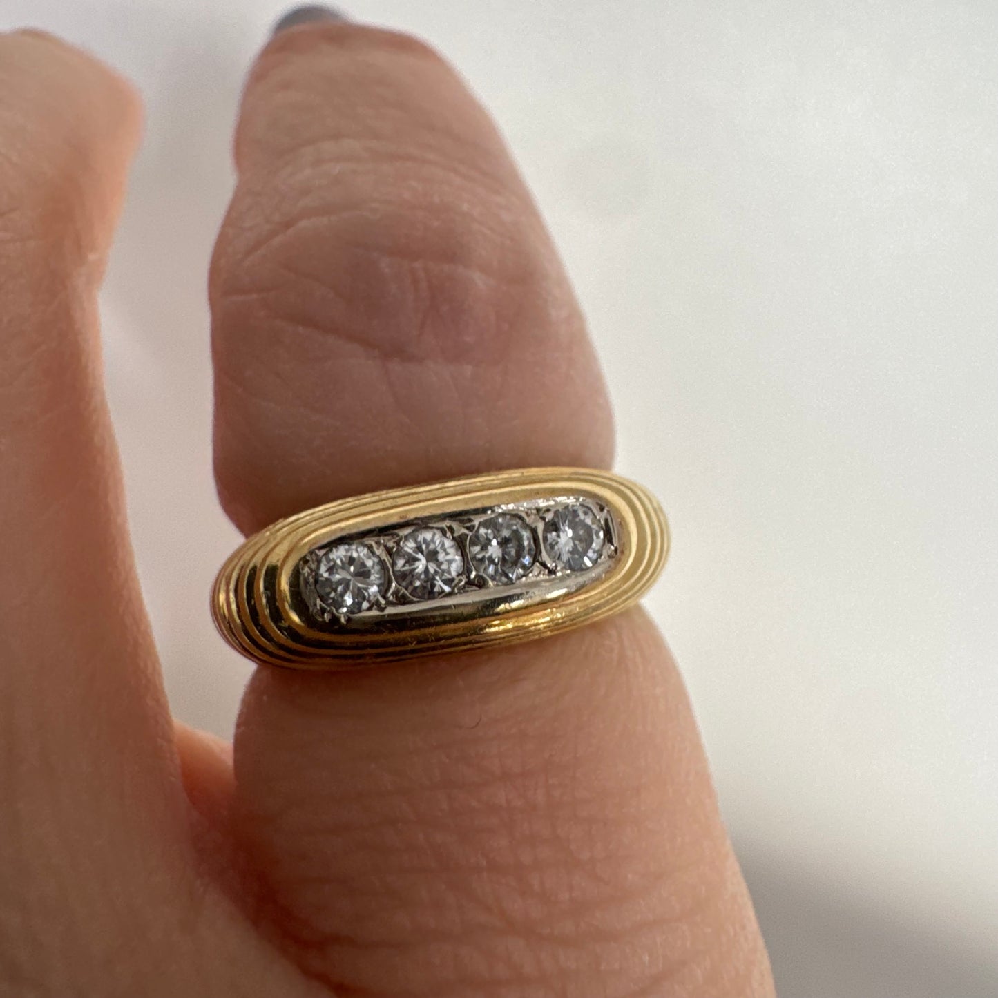 14K gold elongated oval ring set with five round Diamonds in a channel setting.