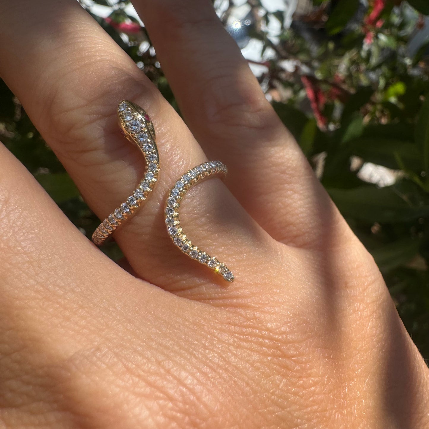 14K gold wrap-around snake ring, fully set with sparkling Diamonds along its body and head, finished with Rubies eyes