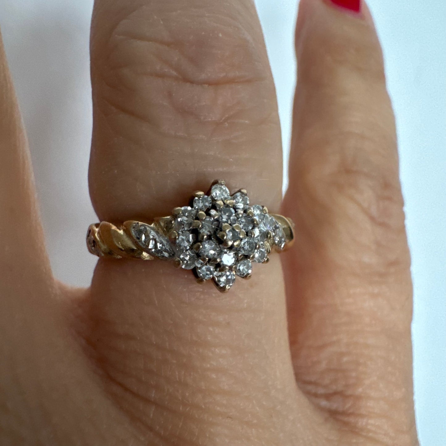 טבעת זהב צהוב 9 קראט משובצת יהלומים בעיצוב פרח עדין.