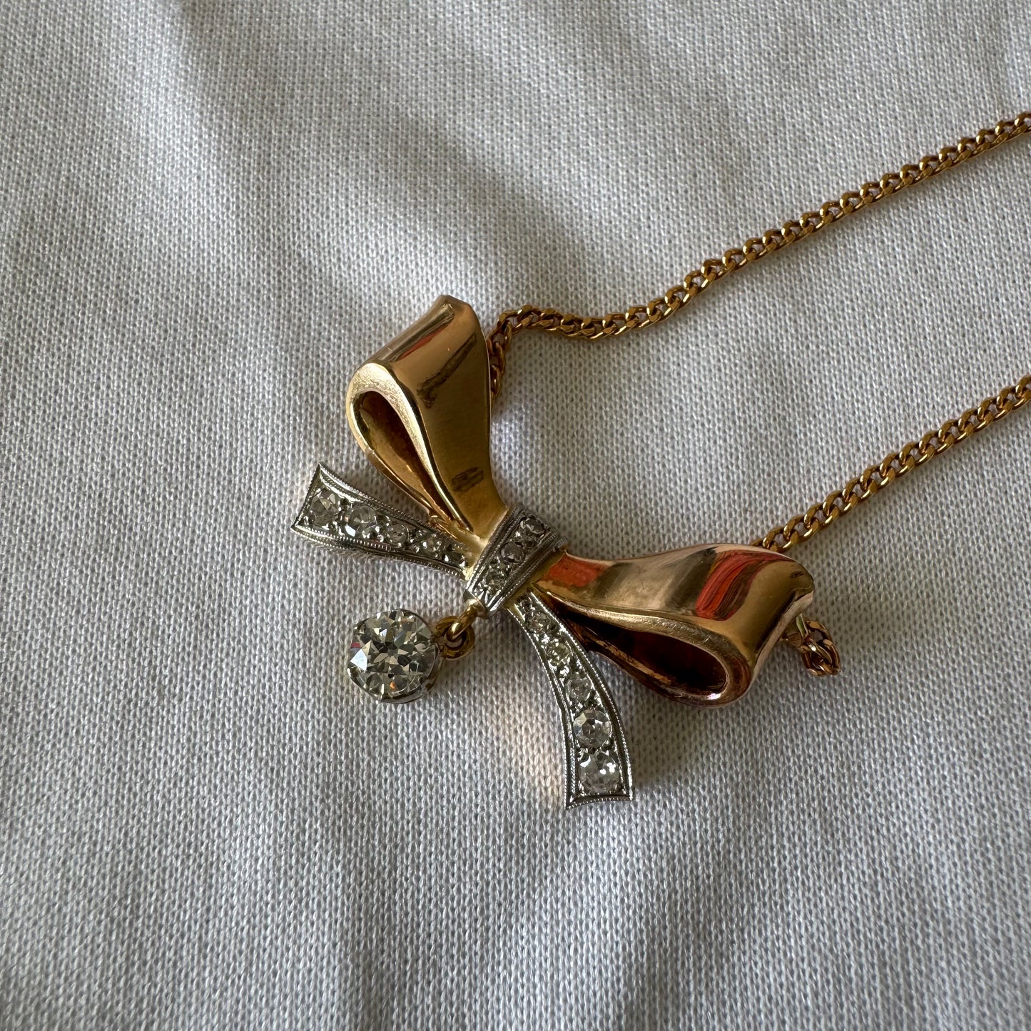 שרשרת זהב 18 קראט עם תליון בצורת סרט קלאסי משובץ יהלומים ונושא יהלום מרכזי תלוי שמוסיף נגיעה של זוהר ואלגנטיות