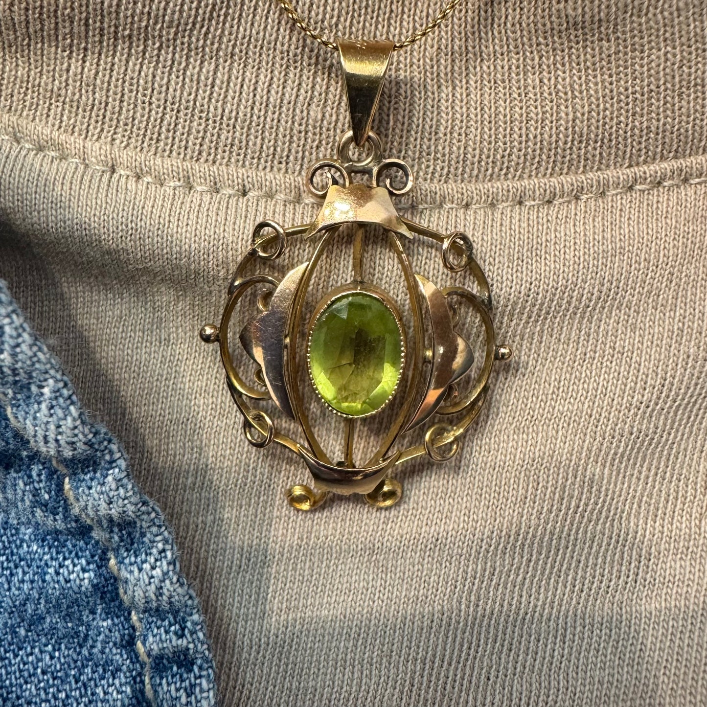 9K gold pendant featuring an oval-cut Peridot in a vibrant green hue.
