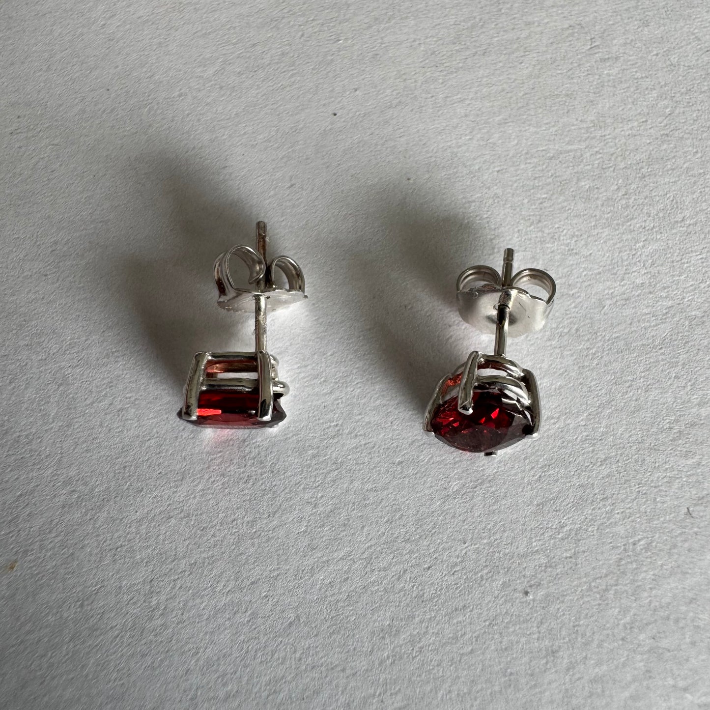 עגילי זהב לבן 14 קראט משובצים אבני גרנט בגוון אדום יין עמוק.