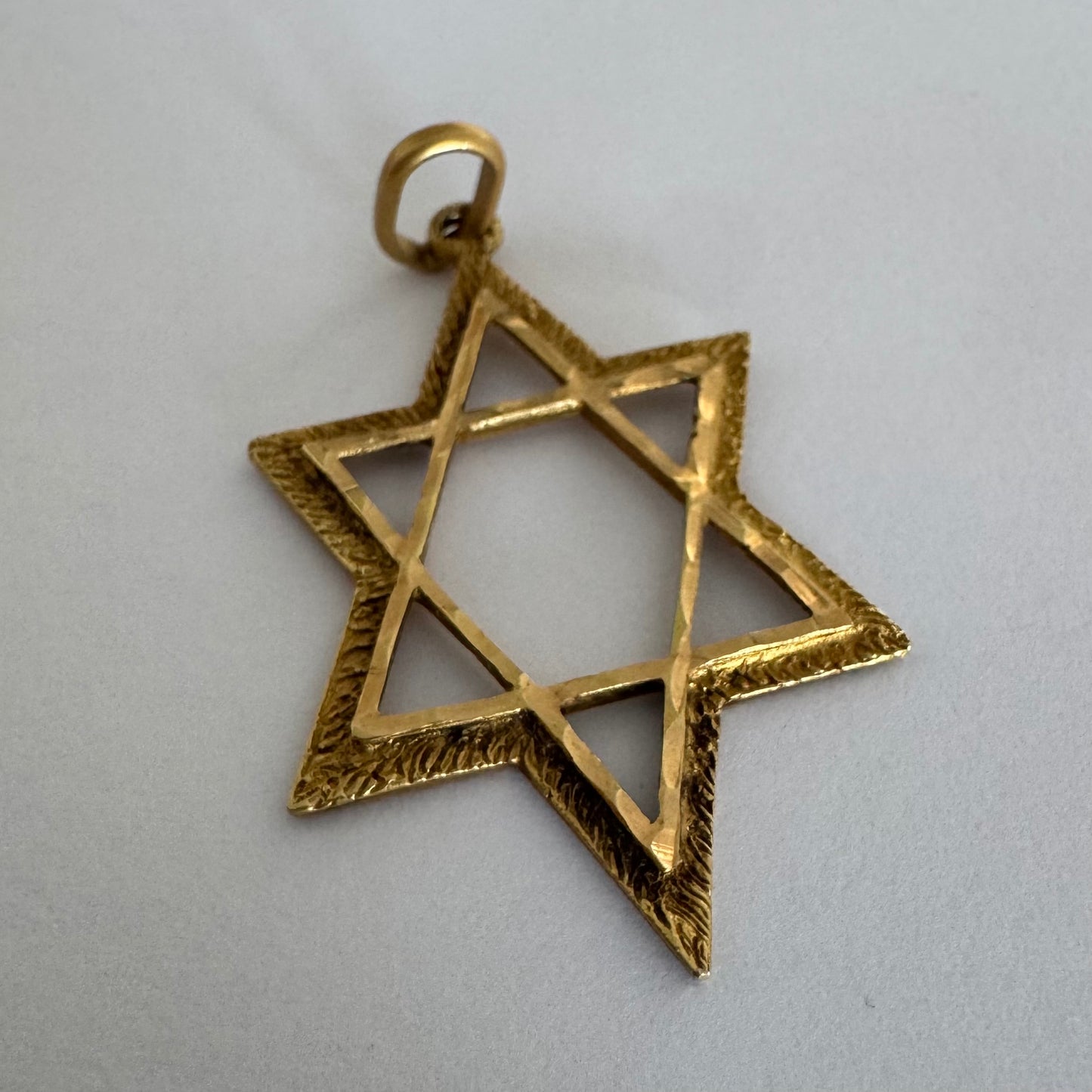 14K gold Star of David pendant with textured detailing and an open design.