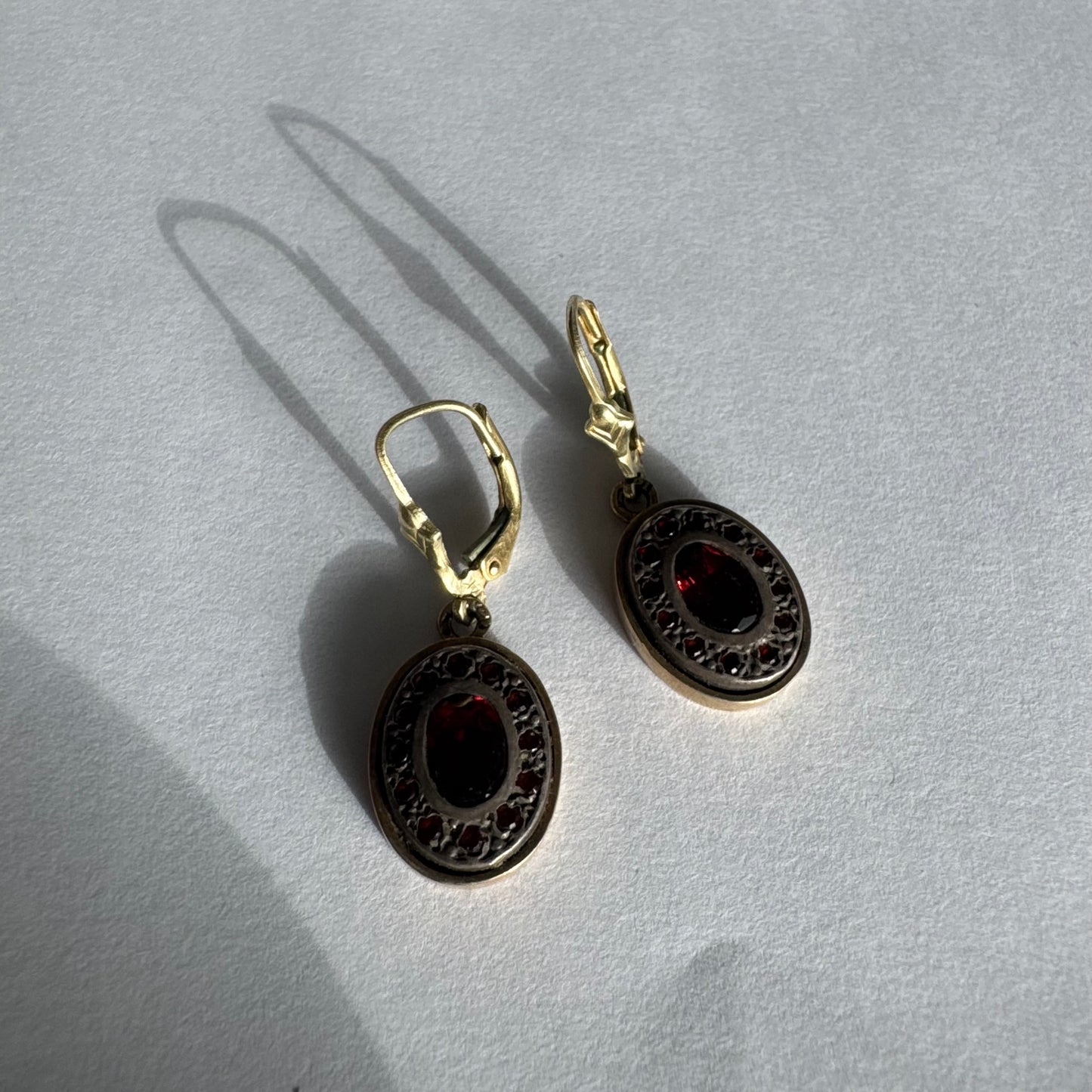 14K gold drop earrings set with deep red oval Garnets surrounded by smaller stones Garnets.