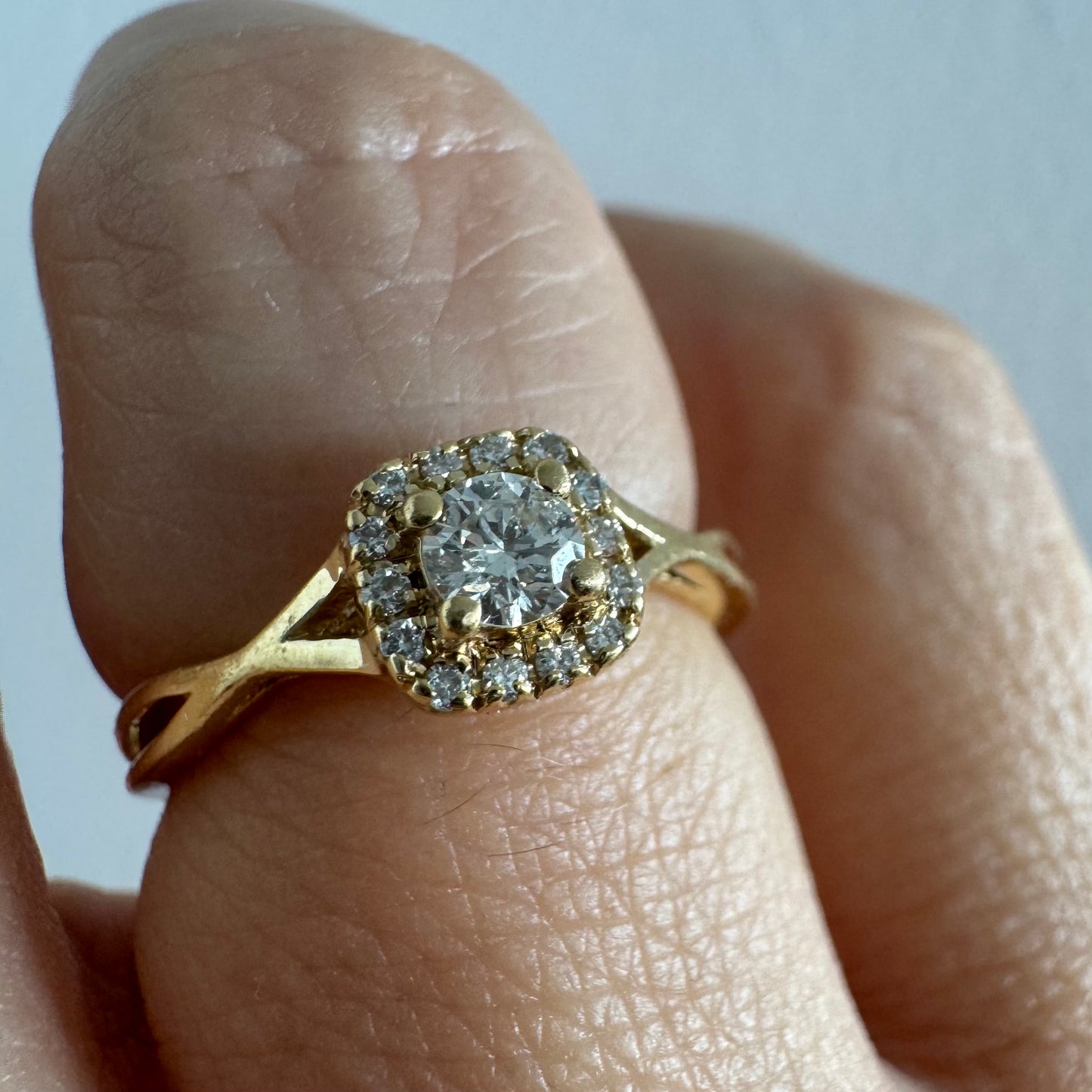 14K gold ring set with a central Diamond surrounded by small Diamonds
