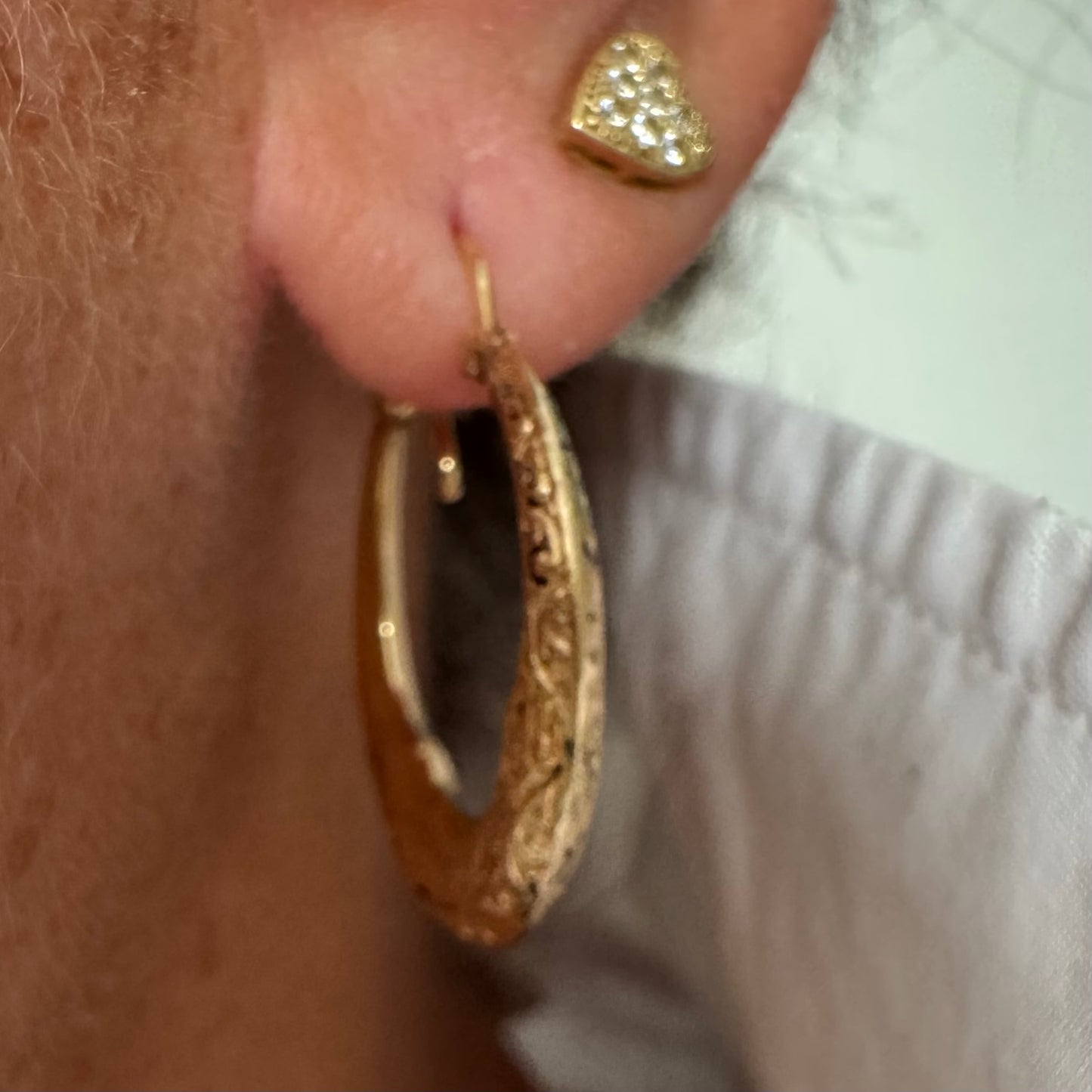 14K gold hoop earrings featuring an intricate openwork design and beautifully detailed engraving