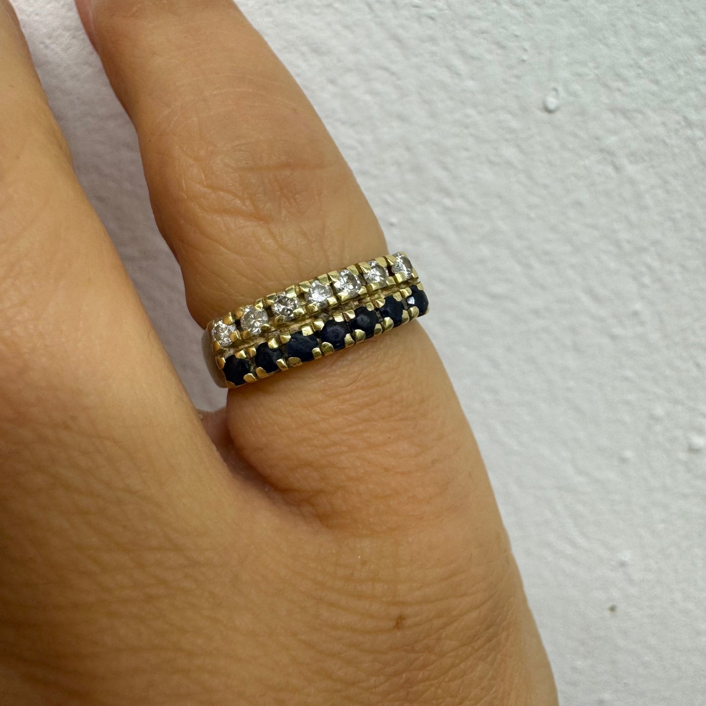 טבעת זהב צהוב 14 קראט, עם שורה של יהלומים נוצצים ושורה נוספת של ספירים כחולים.