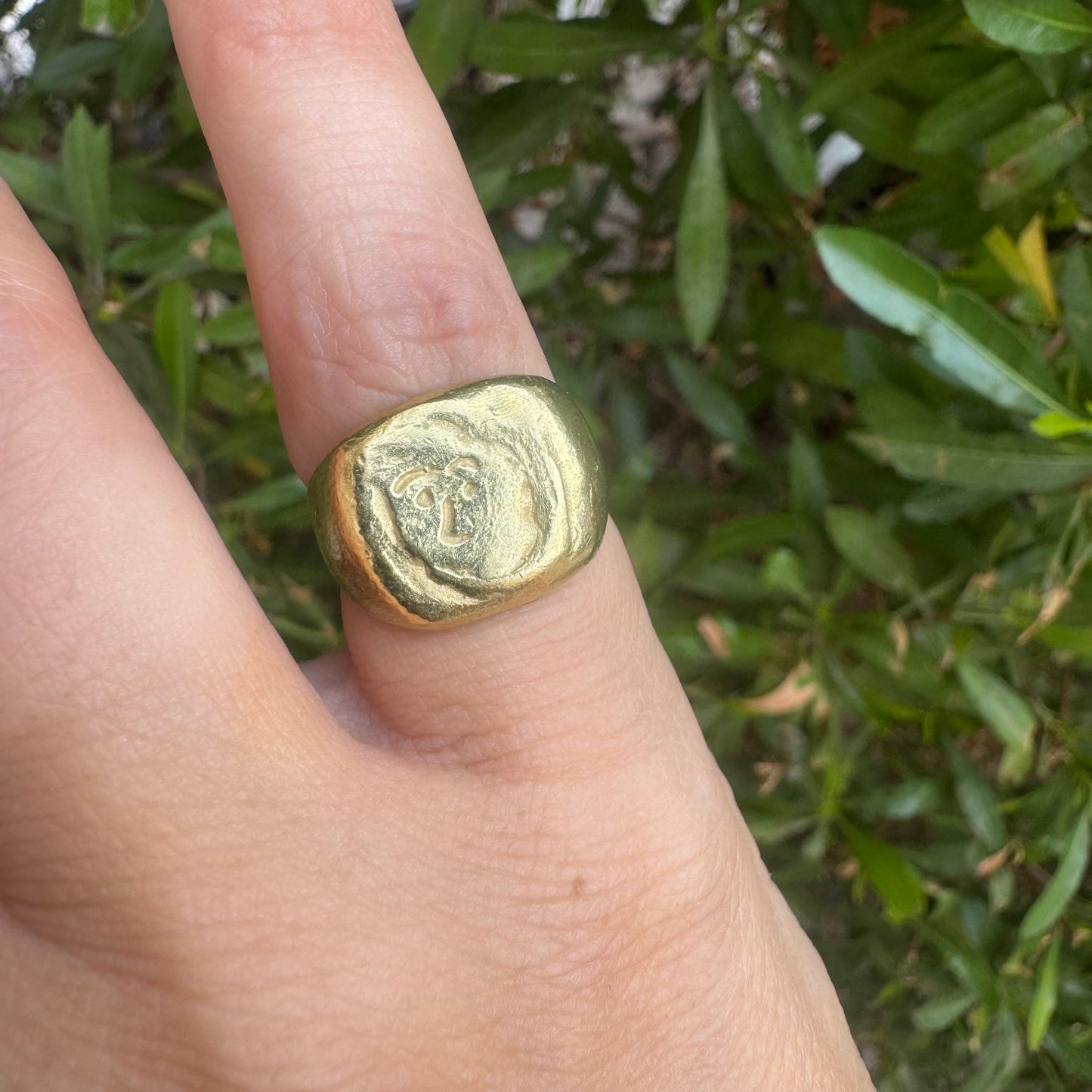18K gold chunky gold ring with a rustic, organic finish, featuring an engraved abstract face motif at its center.