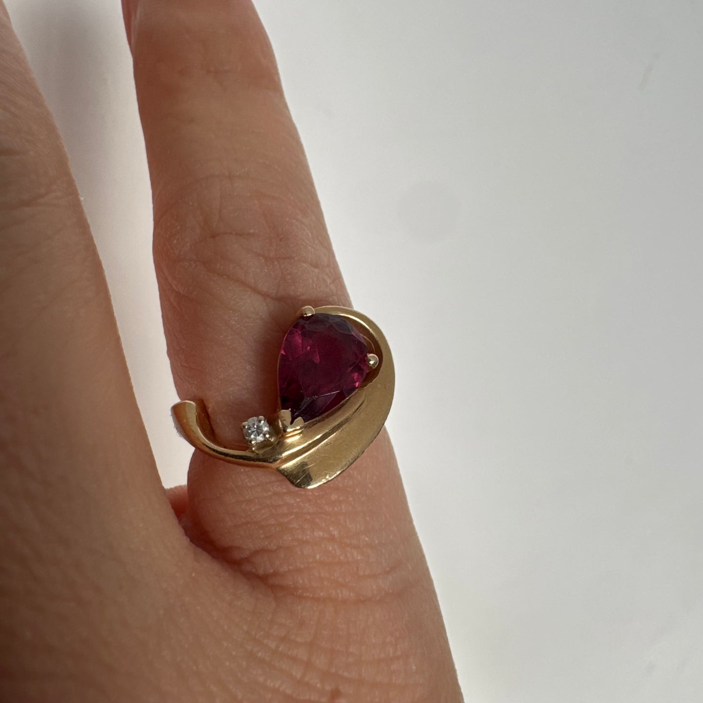 14K gold sculptural open ring set with a pear-cut pink Tourmaline, accented by a small Diamond.