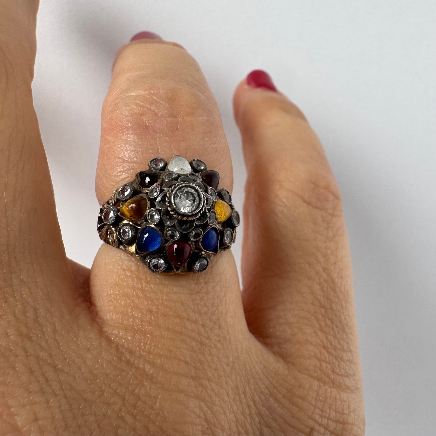 14K gold ring set with a central transparent gemstone surrounded by a vibrant mosaic of colorful gemstones -set in an ornate, handcrafted design