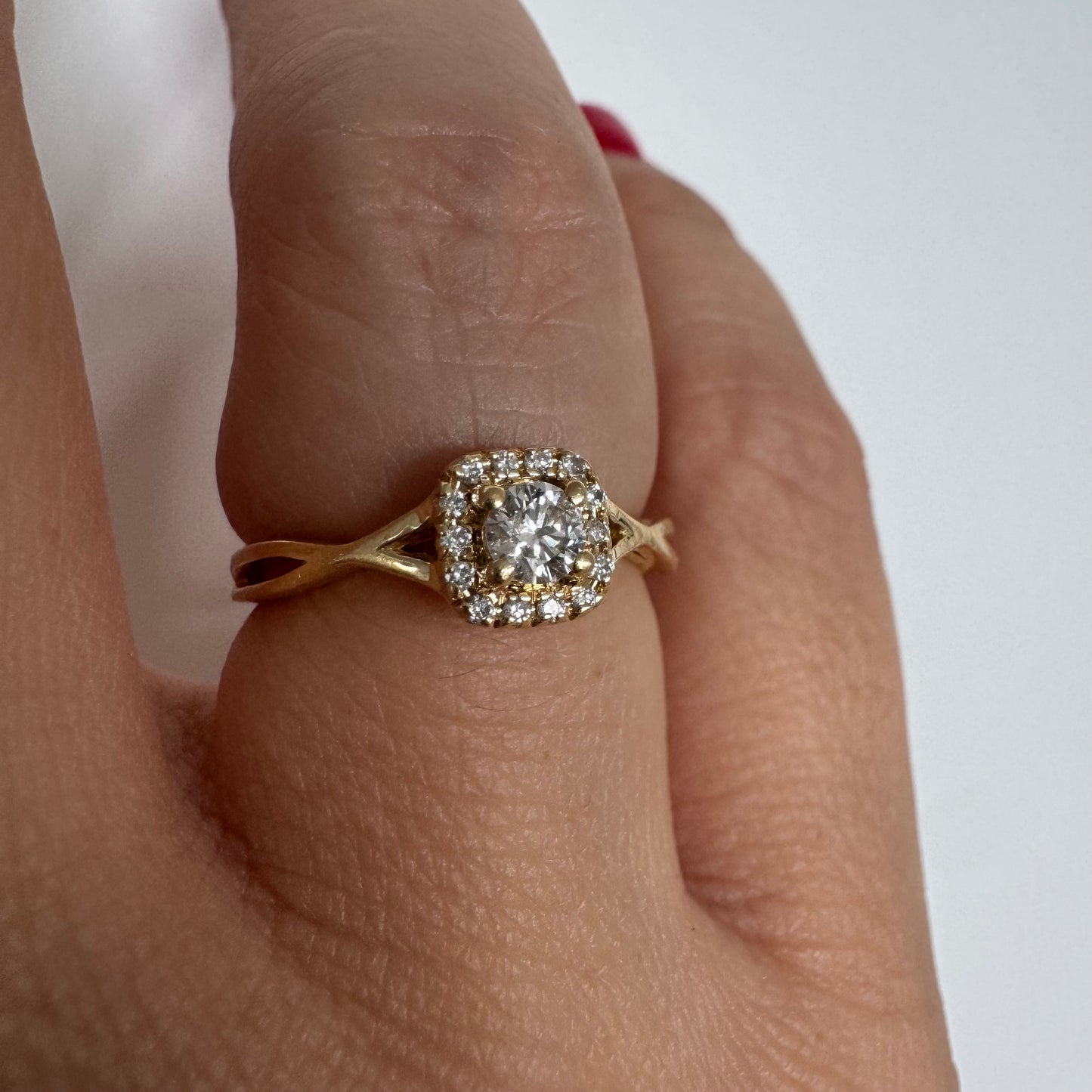 14K gold ring set with a central Diamond surrounded by small Diamonds