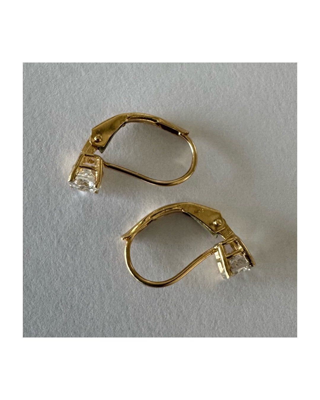 עגילי זהב 14 קראט משובצים יהלום עגול בשיבוץ קלאסי שמדגיש את האור והניקיון של האבן. 