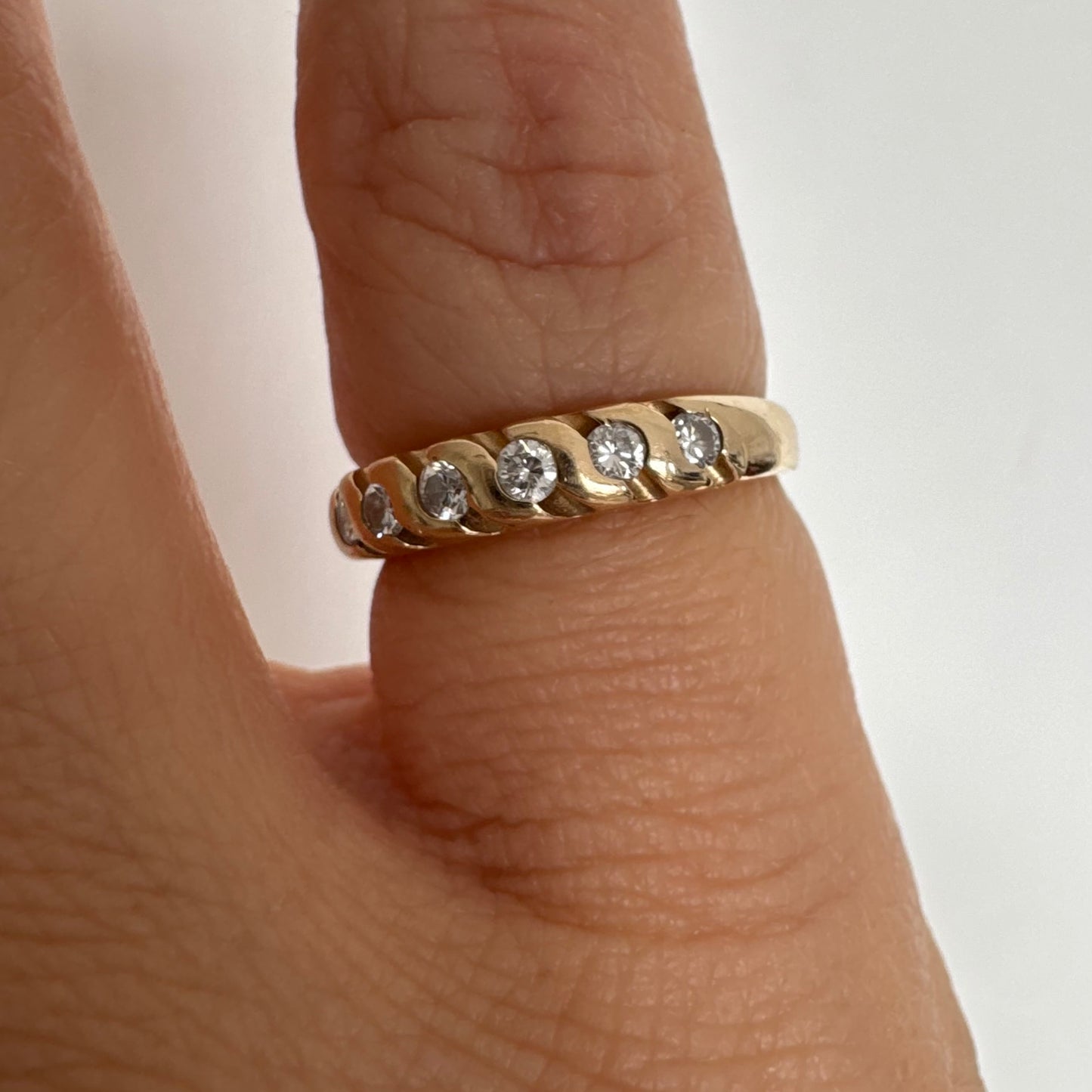 טבעת זהב צהוב 14 קראט משובצת יהלומים בחיתוך עגול, בשיבוץ מחורץ היוצר מראה ייחודי ומלא תנועה.