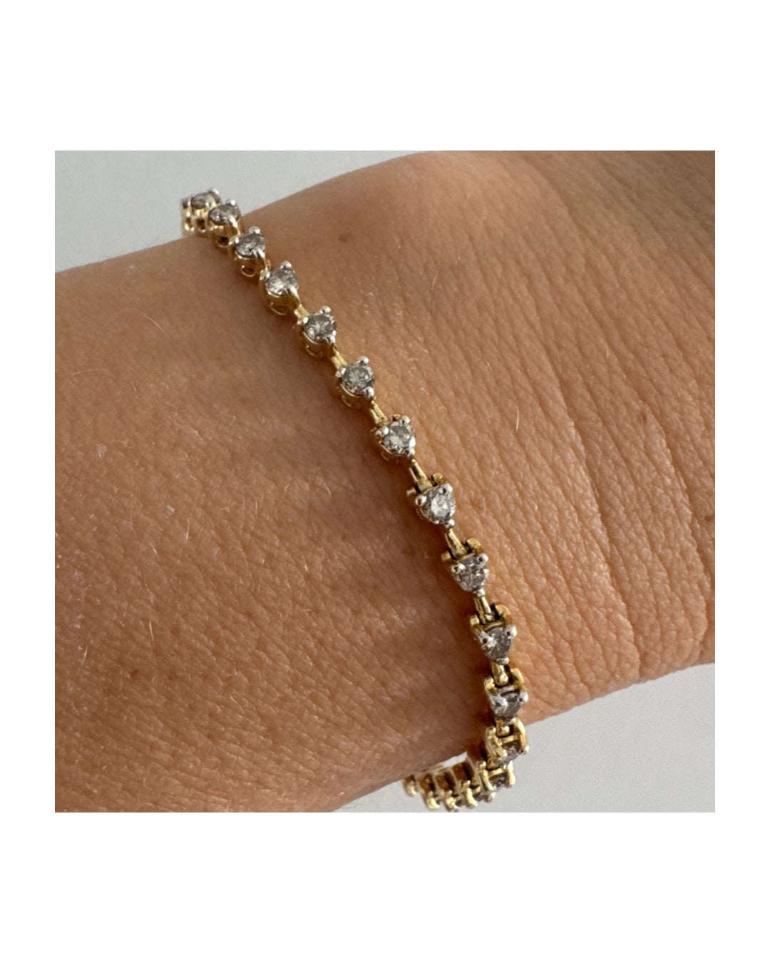 צמיד טניס מזהב צהוב 14 קראט משובץ שורת יהלומים, היוצרים ברק רציף ומראה נקי ועל-זמני.